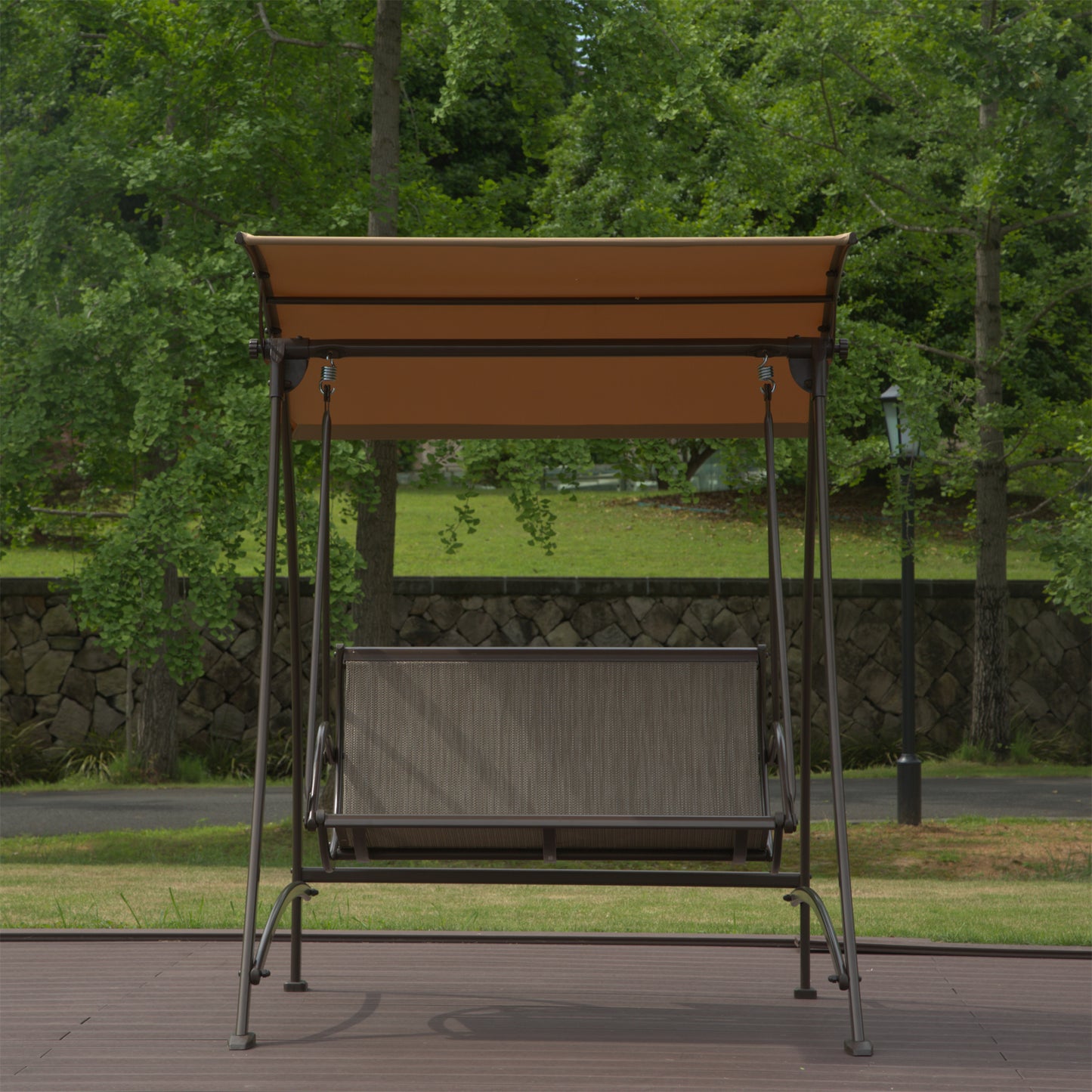 Metal patio swing with brown canopy and gray mesh seat