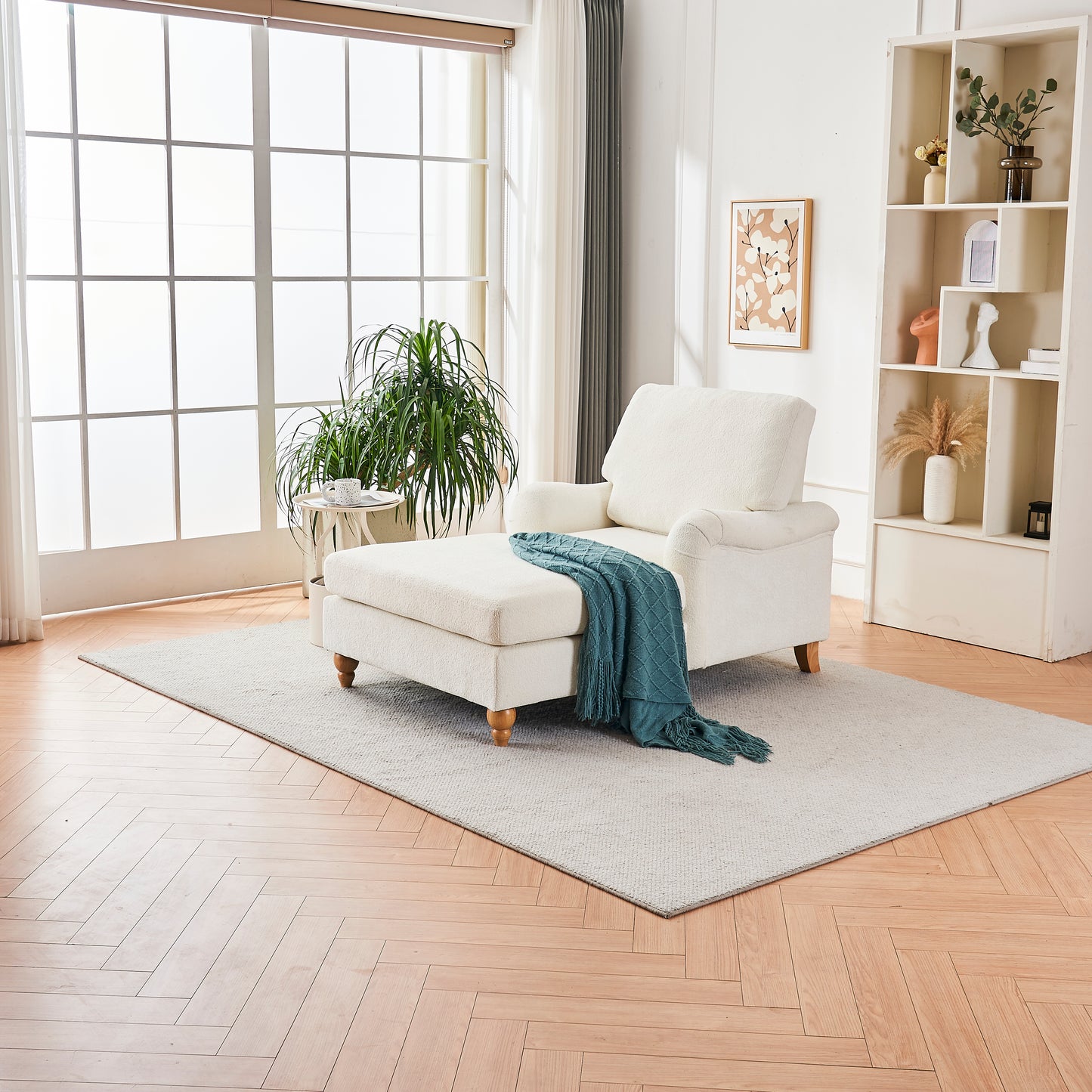 Cream boucl fabric chaise lounge with wooden legs and teal throw blanket