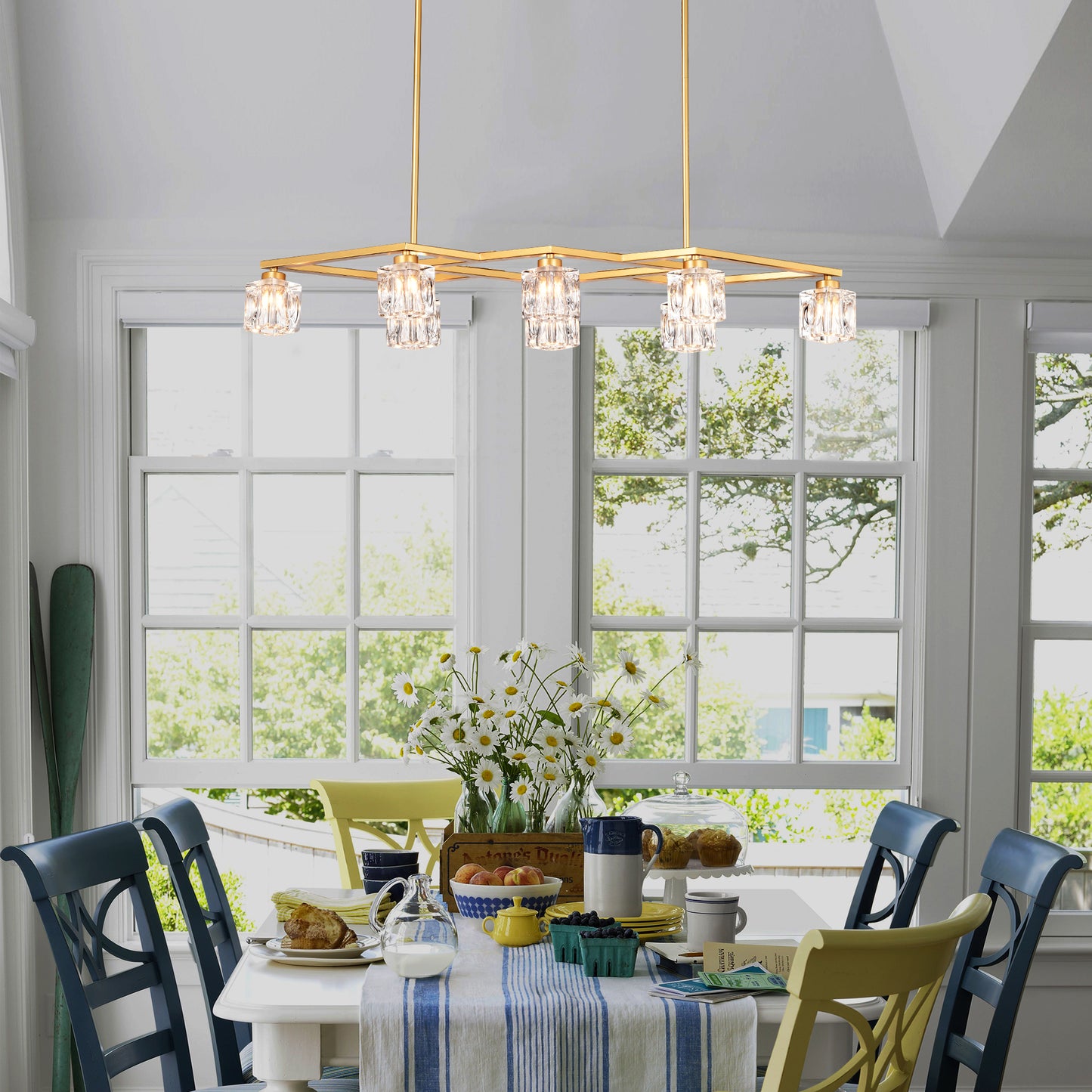 Modern gold chandelier with crystal cube shades hangs above dining table