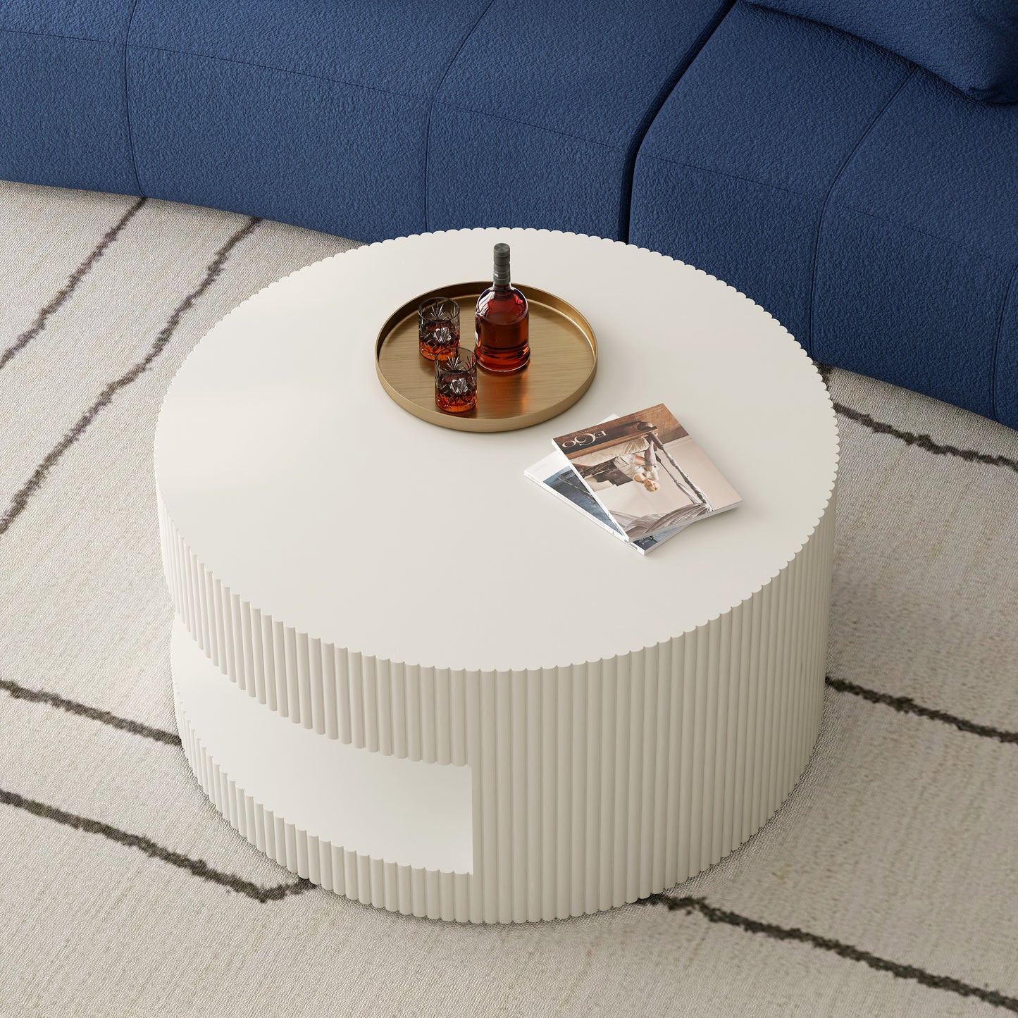 White fluted round coffee table with two shelves featuring a gold tray with whiskey bottle and glasses