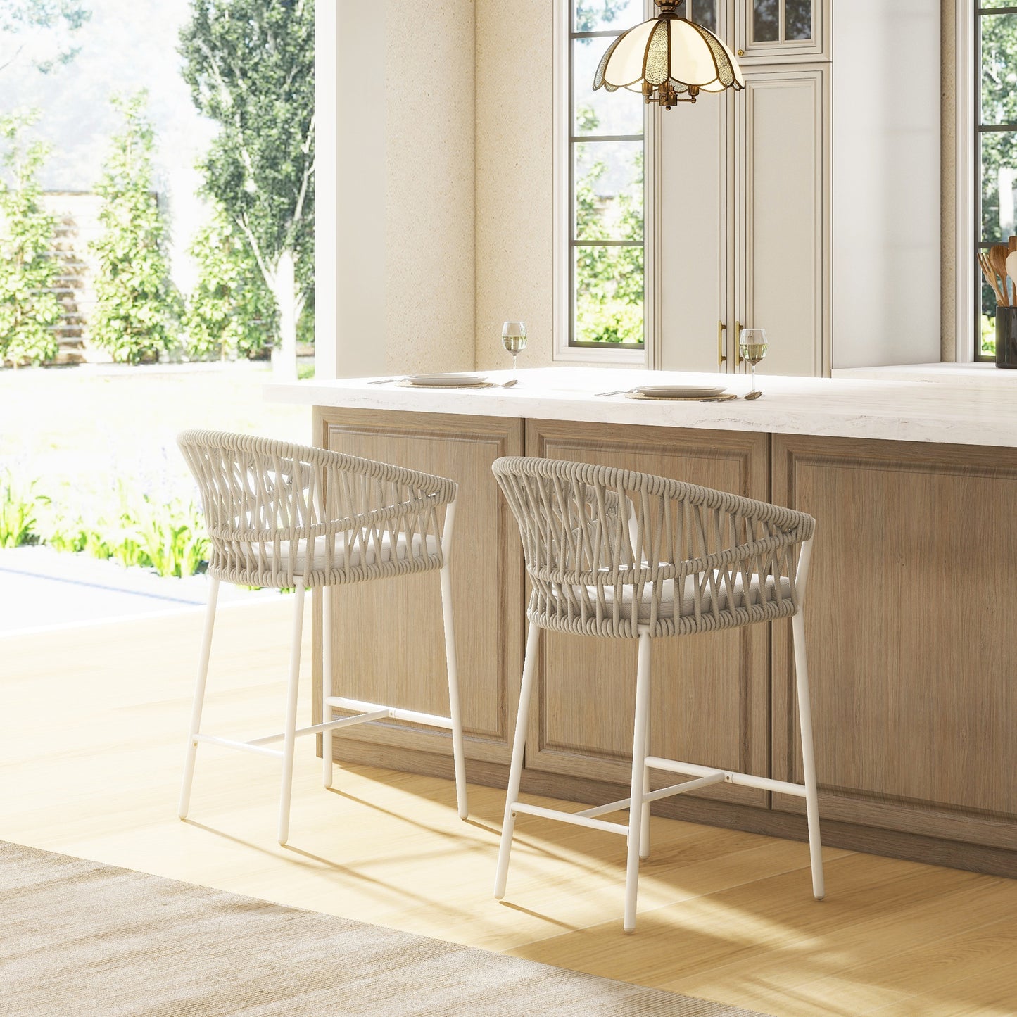 Two light beige wicker bar stools with white metal legs sit at a kitchen island