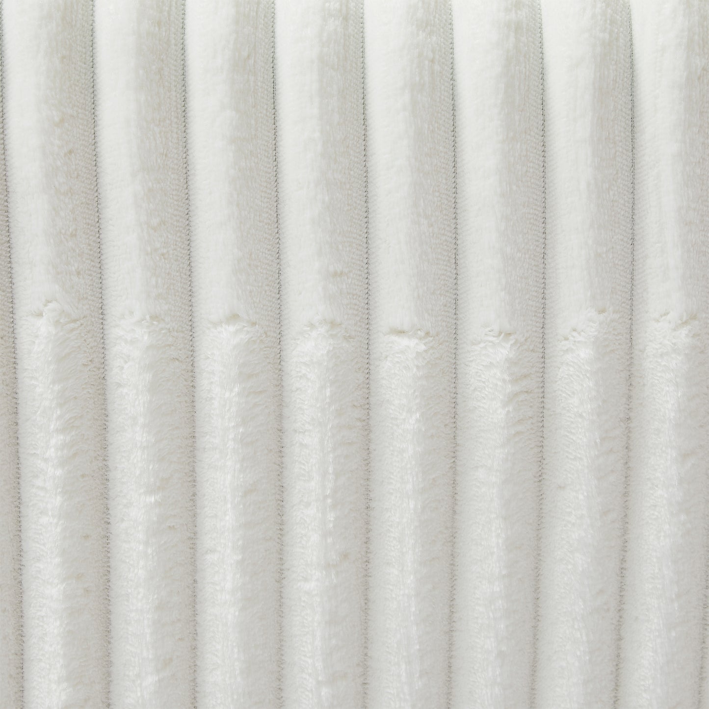 Closeup of textured white plush fabric with vertical ribbed detail perfect for cozy home decor