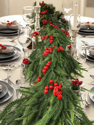 Festive green pine garland with red berries perfect for a Christmas table runner