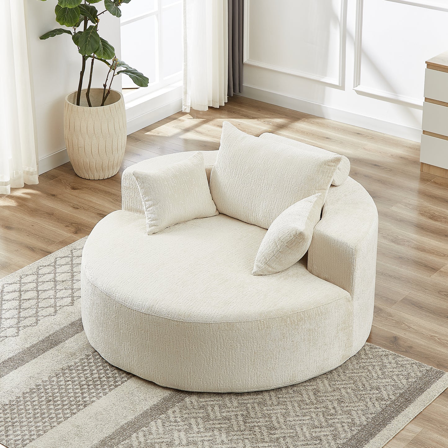 Plush cream boucle circular sofa with accent pillows on a geometric rug
