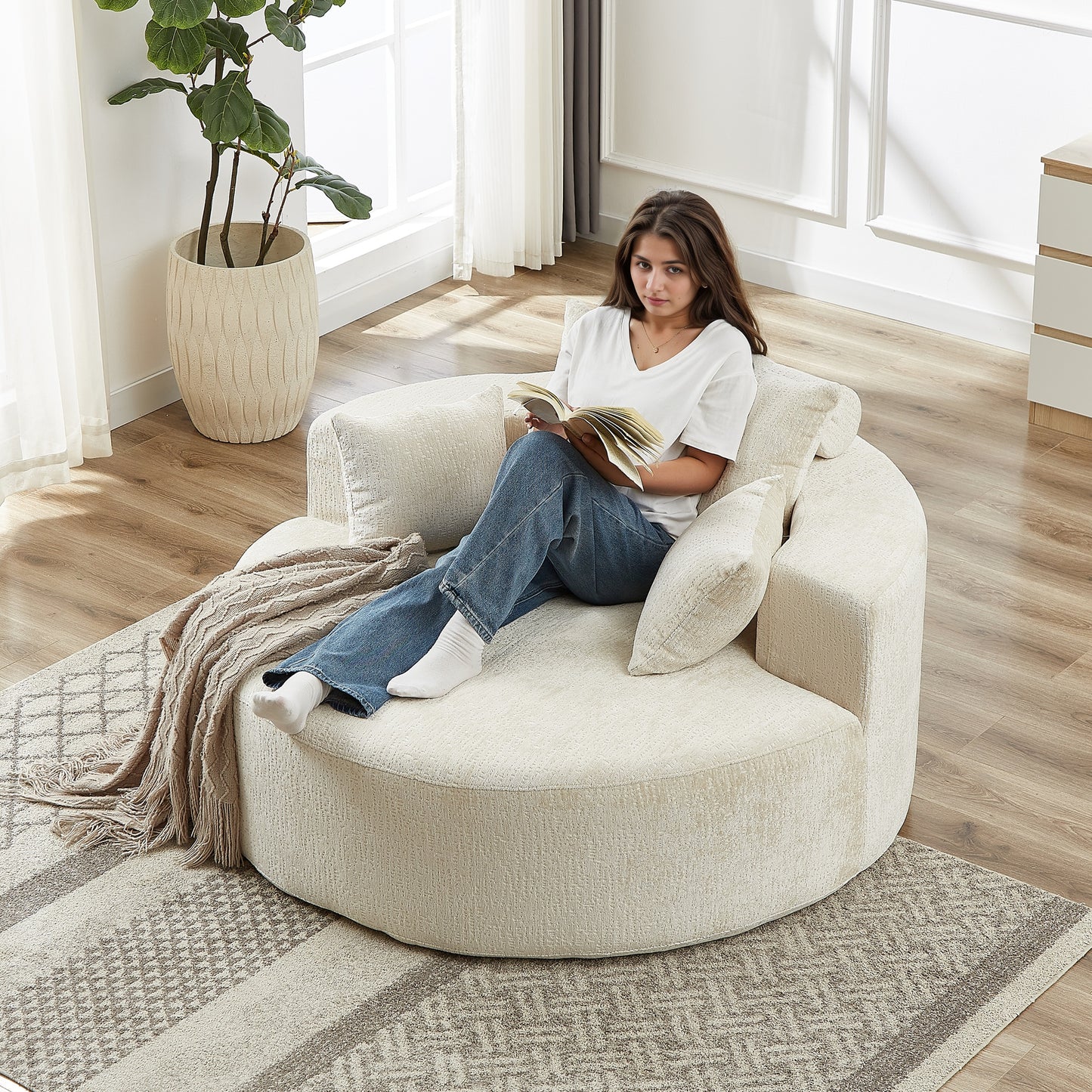 Cozy circular cream boucle fabric accent chair with a woman reading