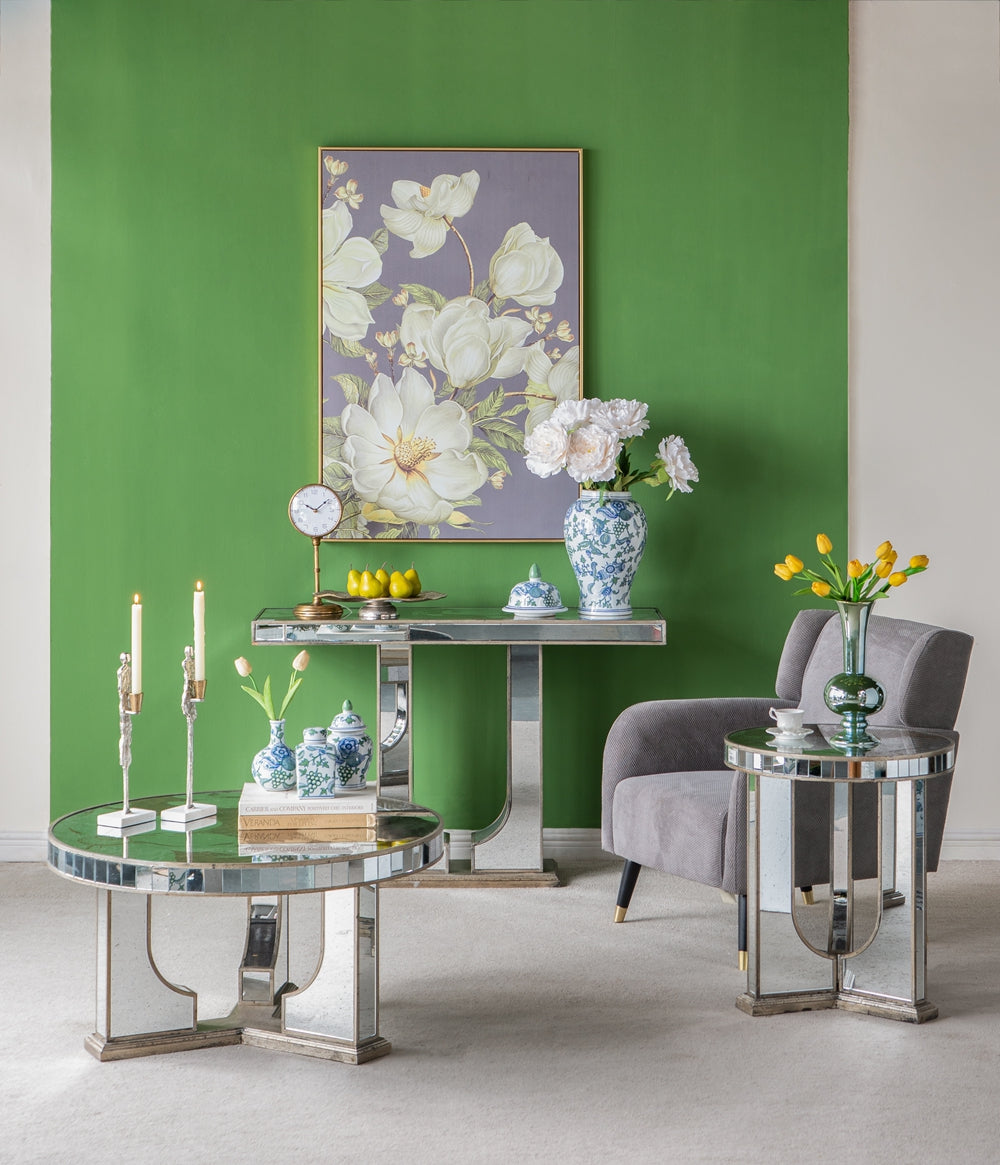 Gilded and mirrored coffee table with ornate candlesticks and a book