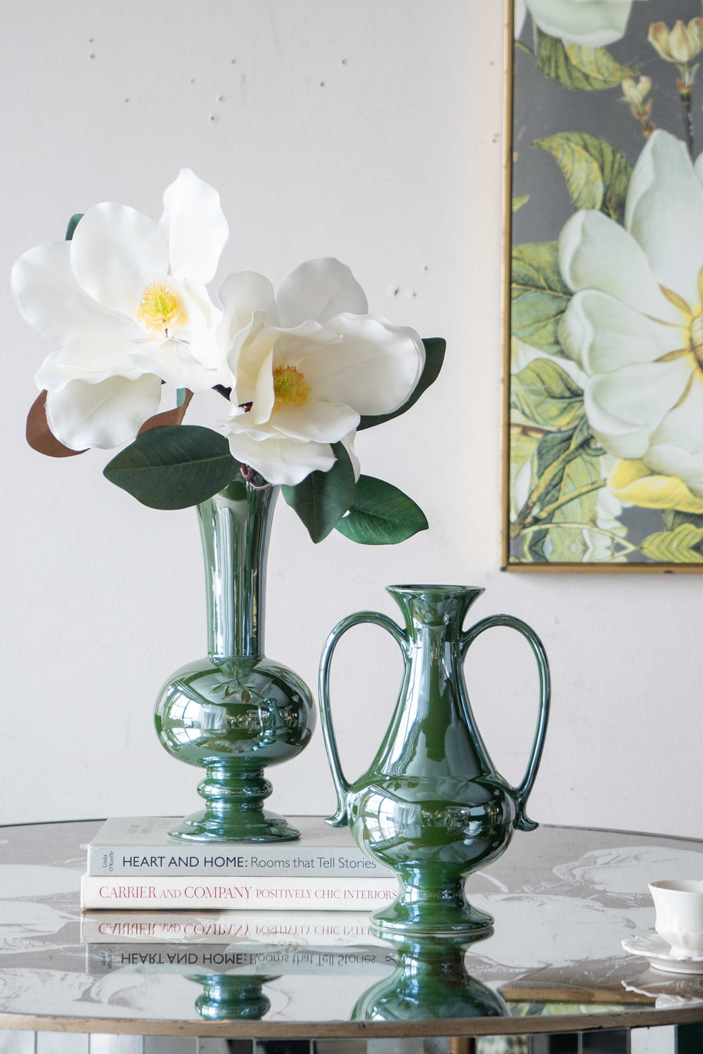 Shiny emerald green ceramic vase with white magnolia flowers for elegant home decor