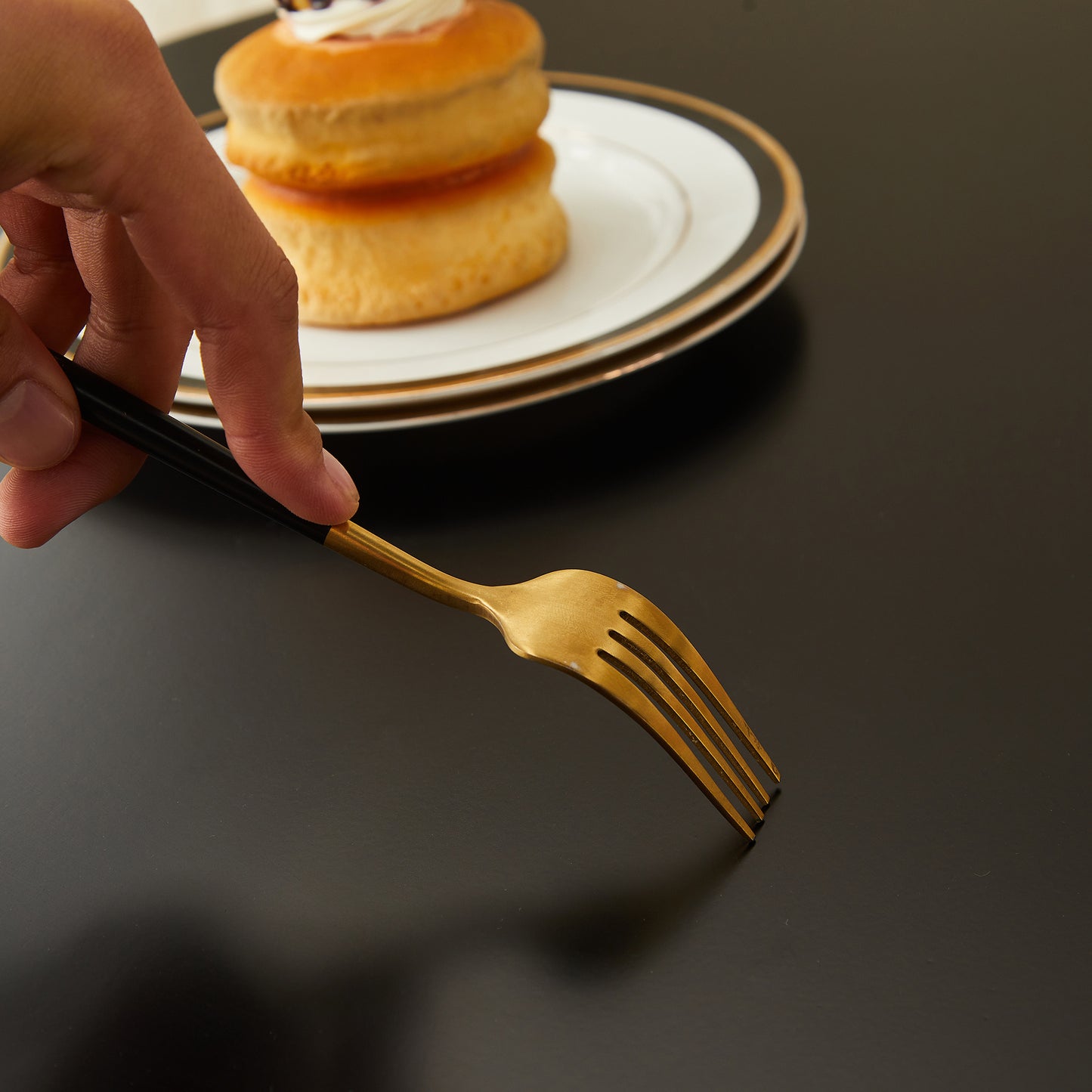 Elegant brushed gold dessert fork with black handle perfect for pastries