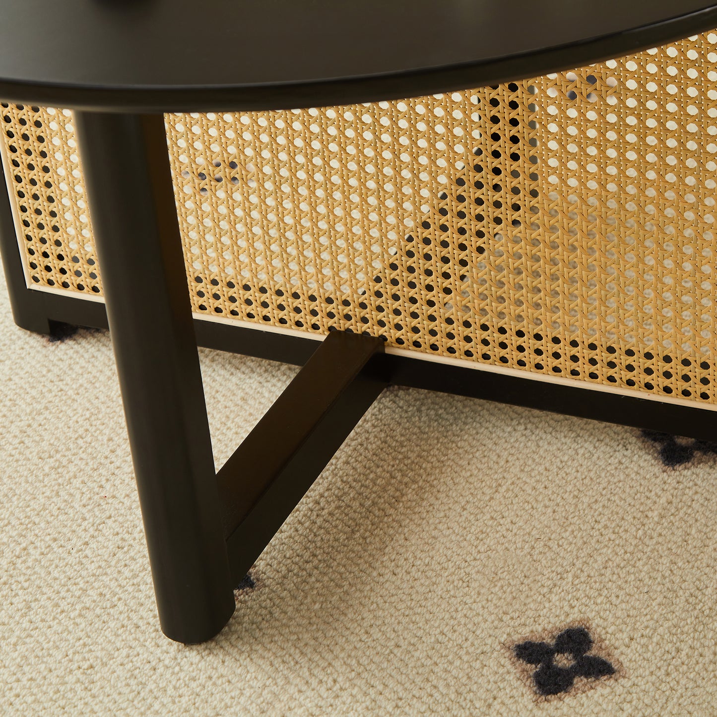 Black metal table leg on woven cane side panel with natural texture