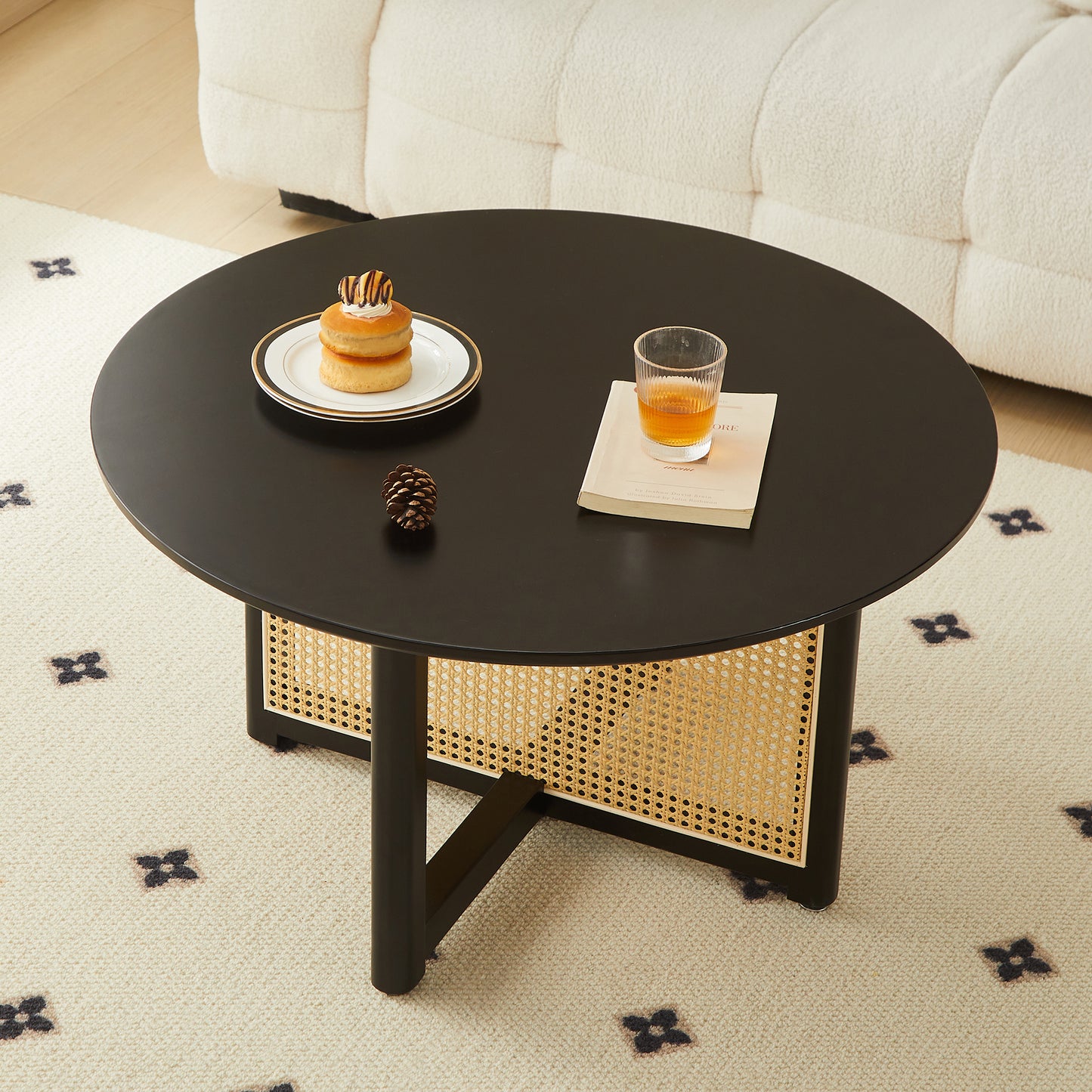 Round black coffee table with cane detailing and minimalist design