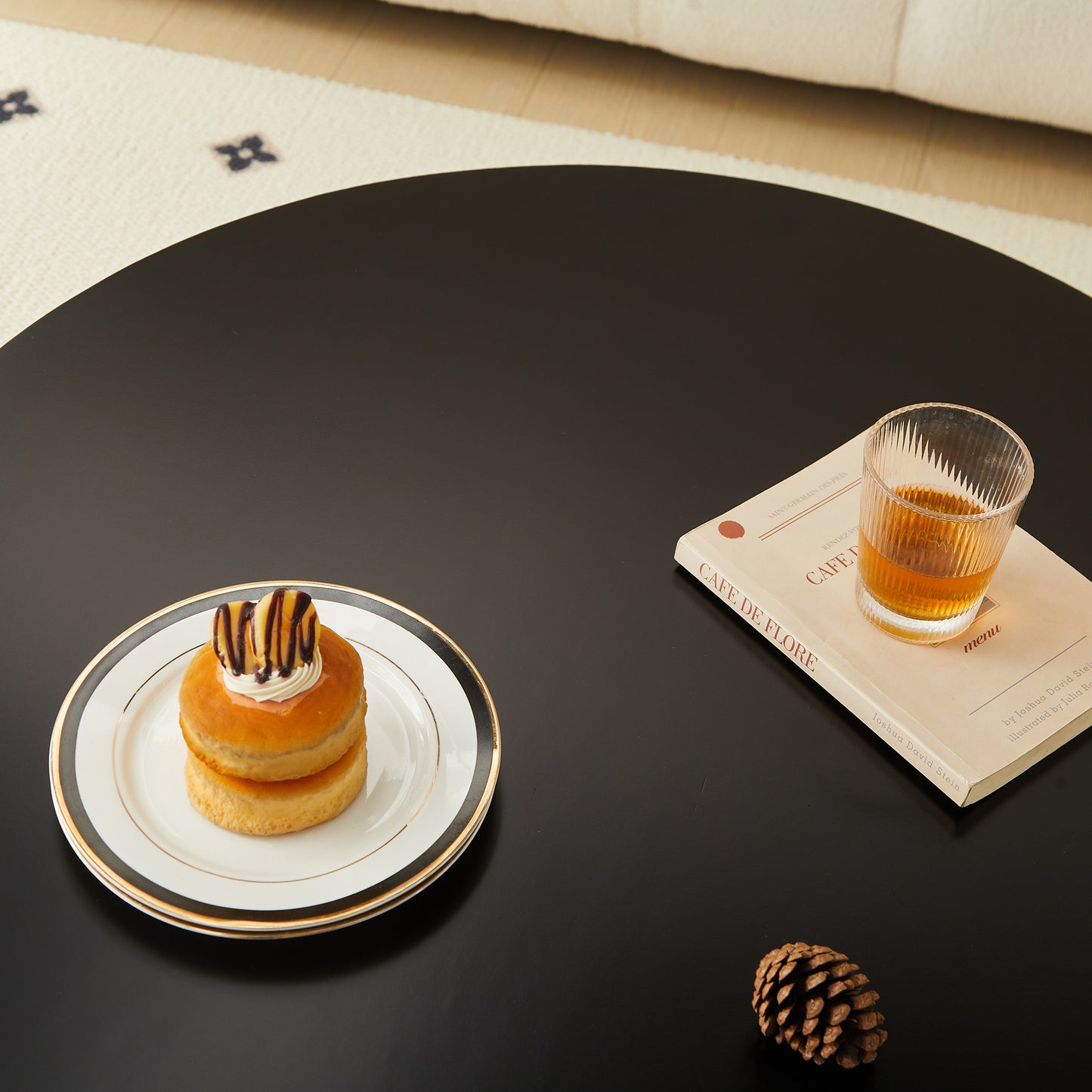 Stacked glazed donuts with chocolate drizzle on a white and gold rim plate