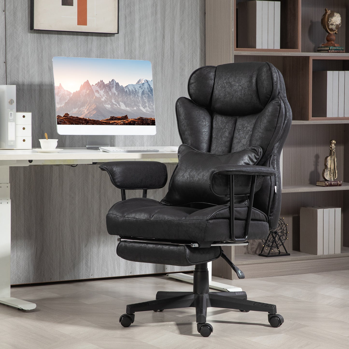 Plush black faux leather executive chair with lumbar pillow and retractable footrest