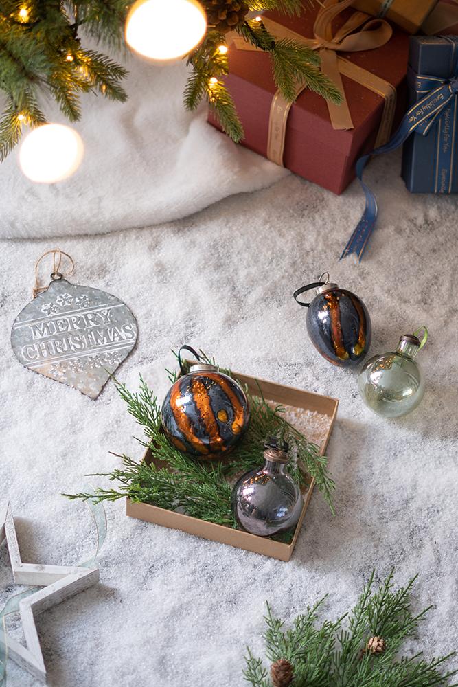 Glass Christmas ornament with orange and black stripes ideal for tree decor
