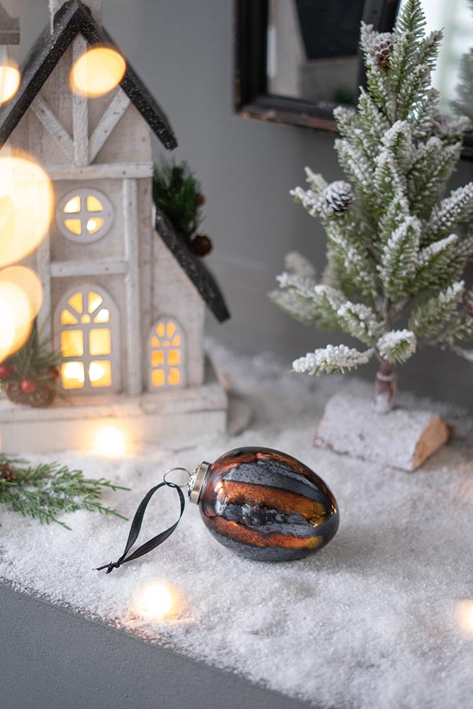 Glistening oval Christmas ornament with black and copper stripes