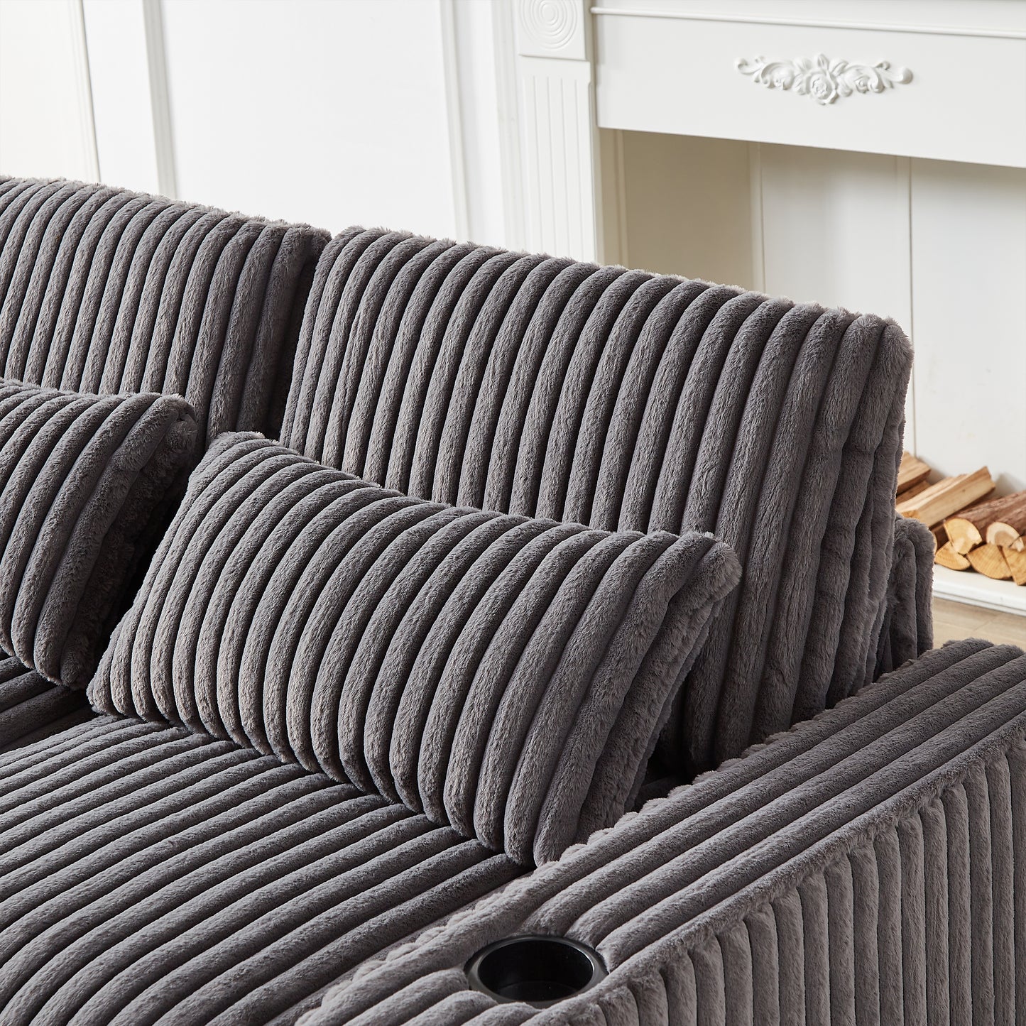 Plush gray corduroy sofa with accent pillows and cup holder detail