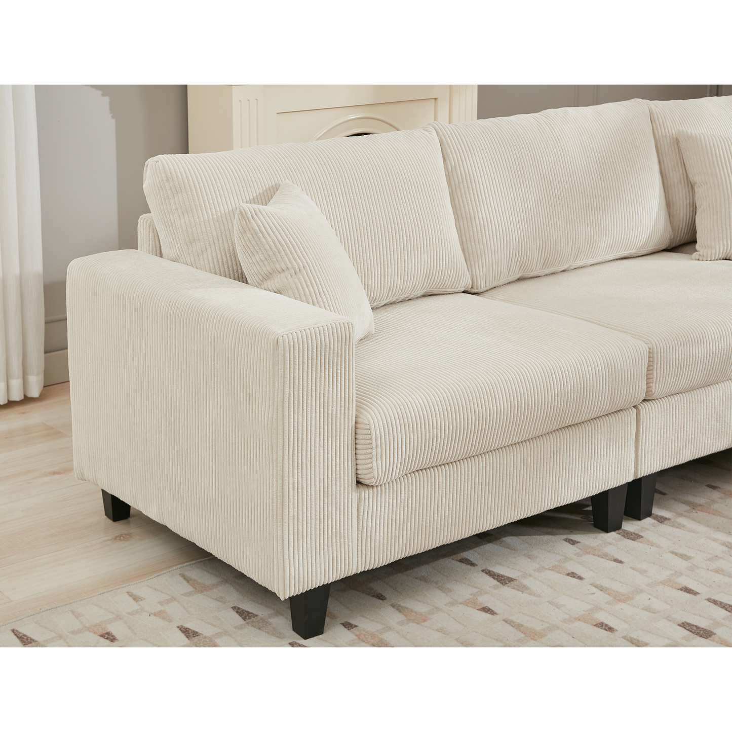 Cream corduroy sectional sofa with plush cushions and dark tapered legs