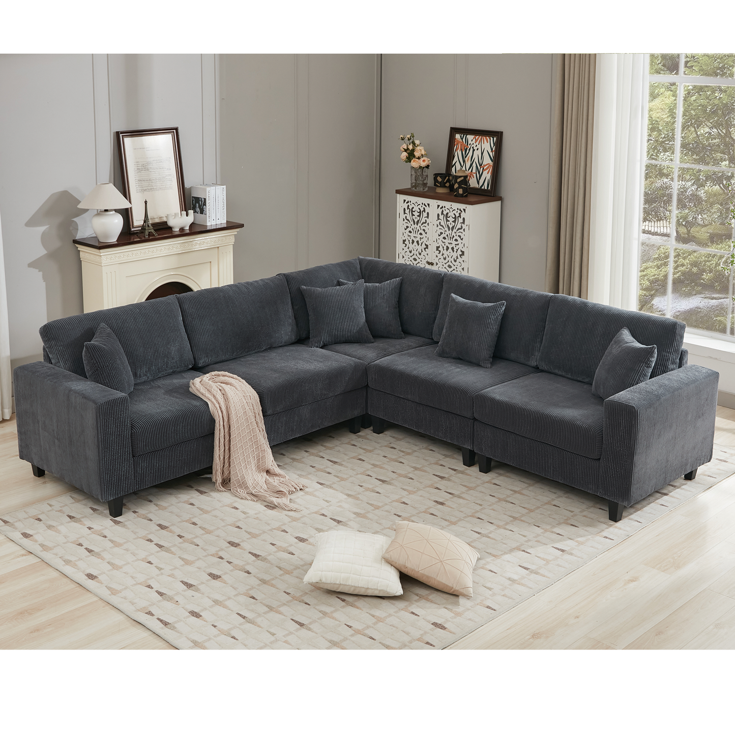 Deep charcoal grey corduroy sectional sofa with plush cushions and throw blanket
