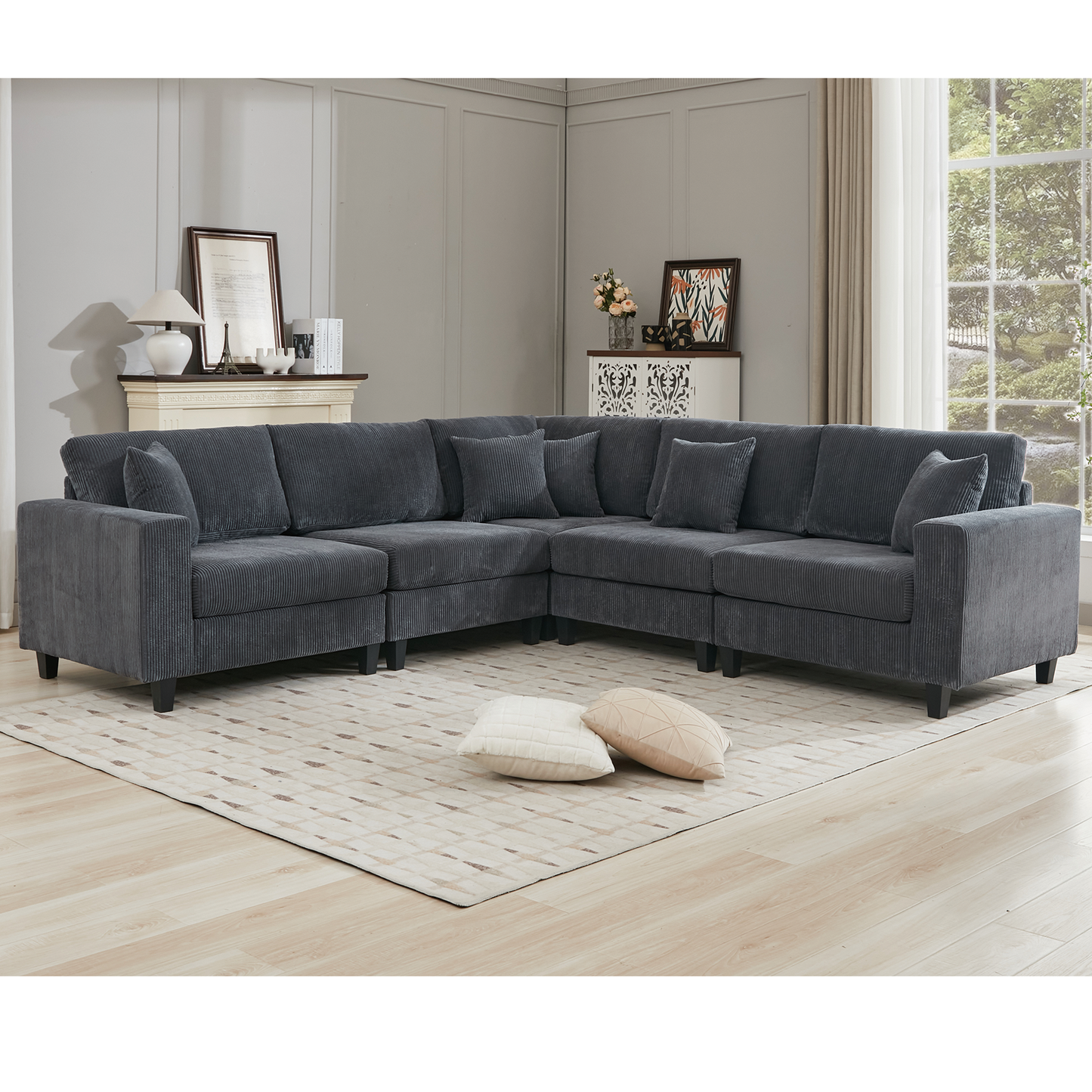Dark gray corduroy sectional sofa with throw pillows on a geometric rug