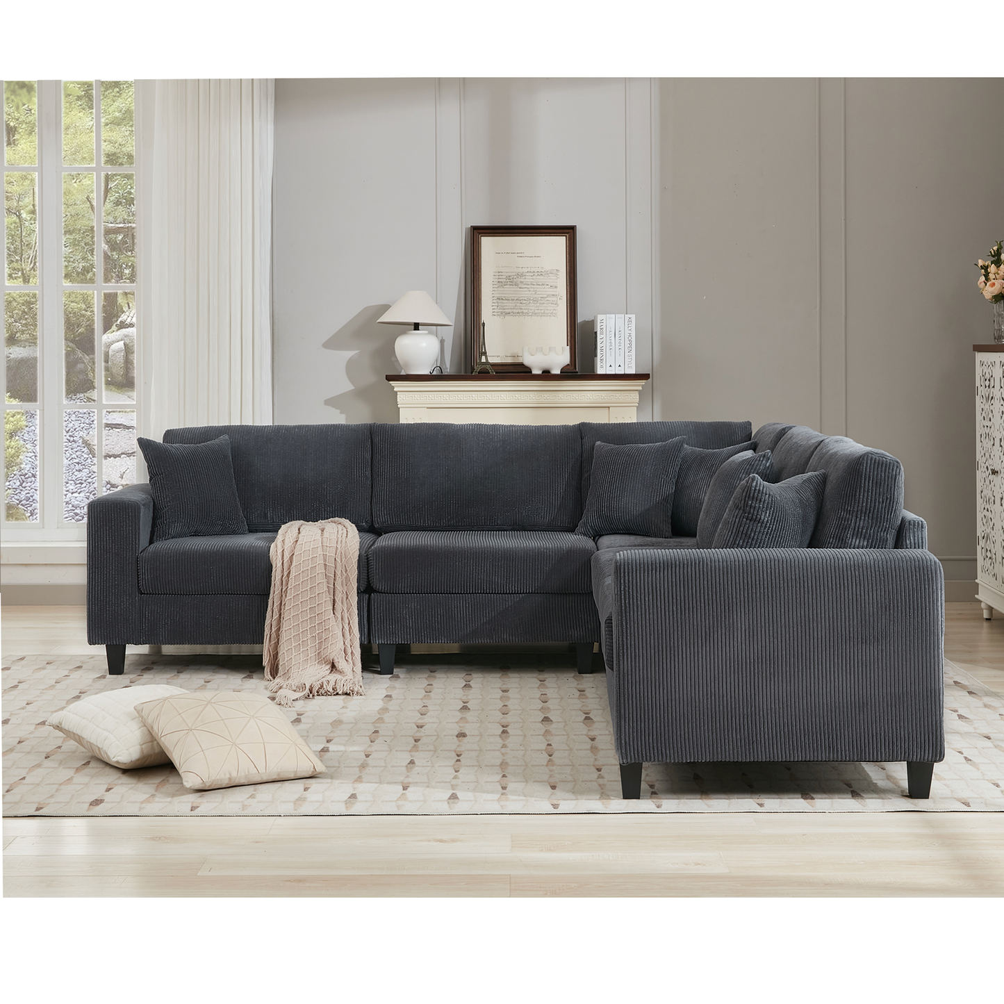 Dark grey corduroy sectional sofa with plush cushions and a cream throw blanket