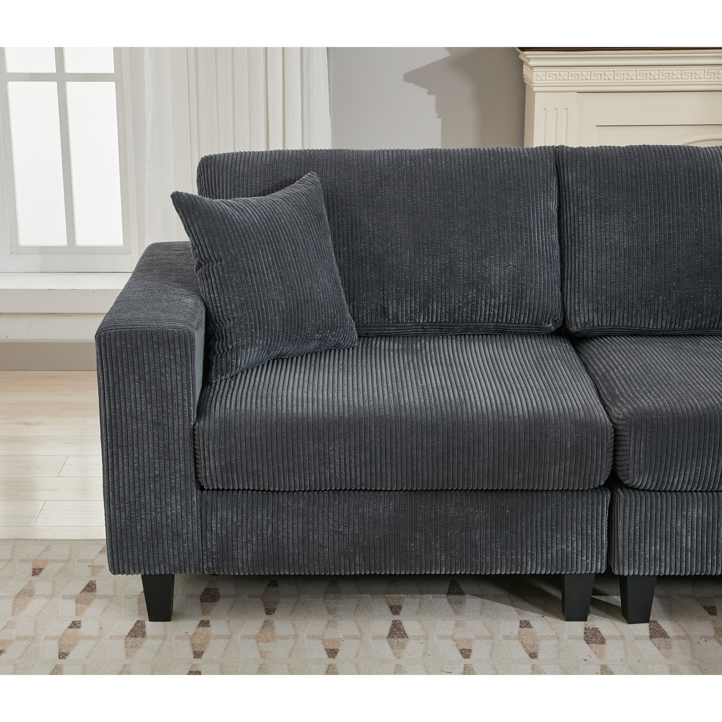 Dark gray corduroy sectional sofa with plush cushions and a matching throw pillow