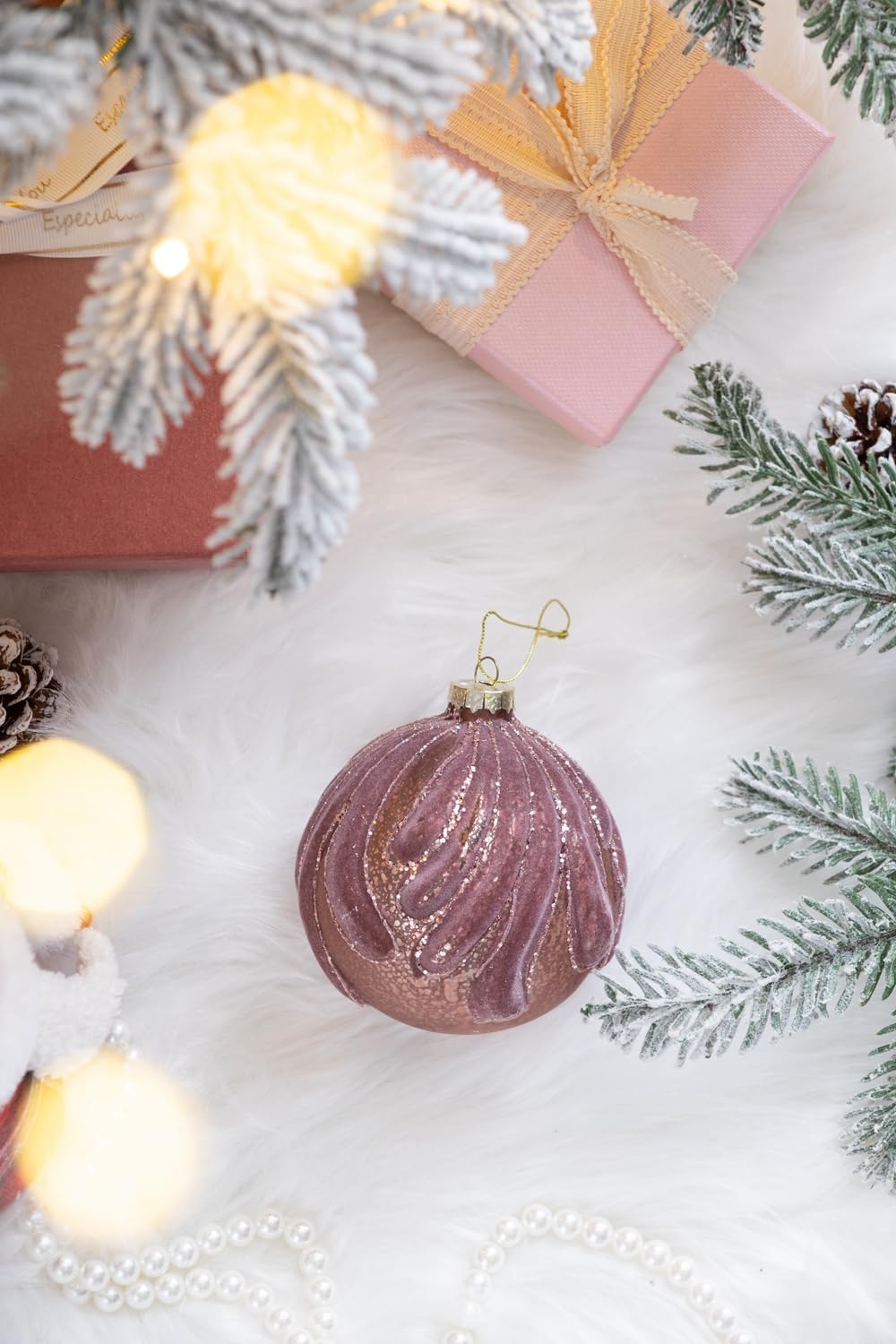 Rose gold glitter glass Christmas ornament with swirling pattern