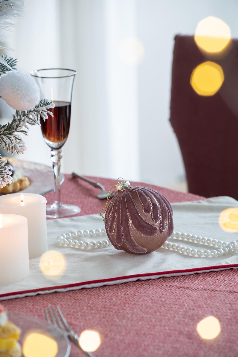 Textured mauve glass Christmas ornament with gold string and swirling design