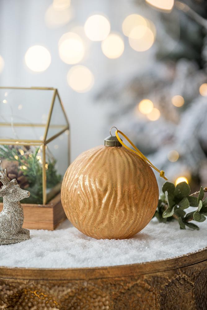 Textured gold Christmas ornament with ribbed surface and yellow hanging loop
