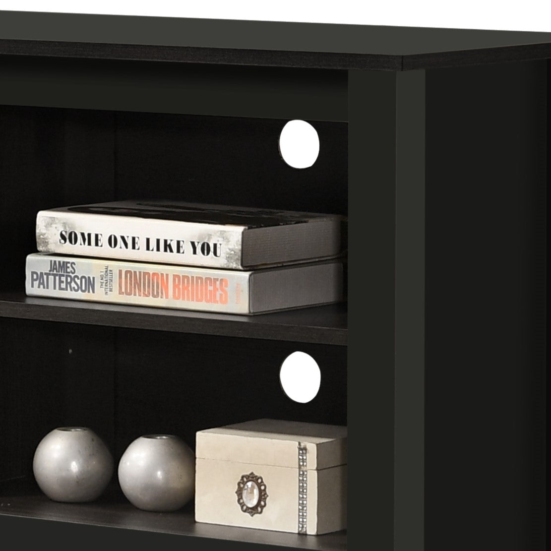 Black media console shelf with two books and decorative spheres for modern living room