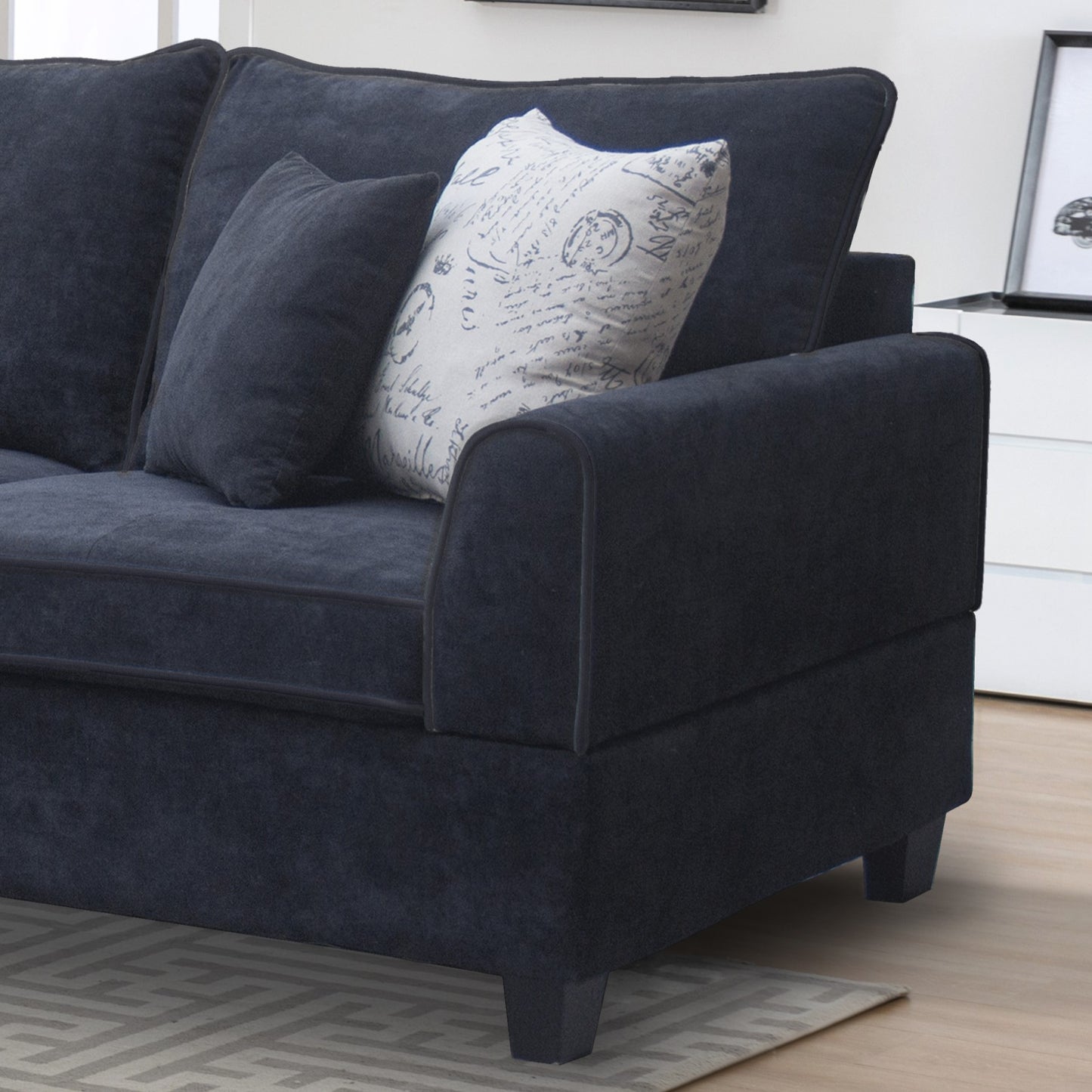 Dark navy blue fabric sofa with decorative script pattern accent pillow