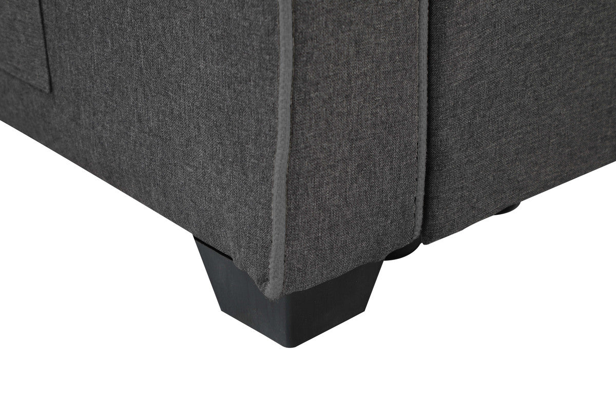 Closeup of dark gray fabric sofa corner with black square feet