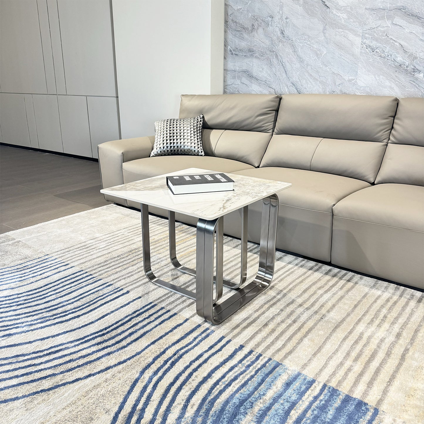 Light gray leather sofa with plush cushions and a modern geometric accent pillow