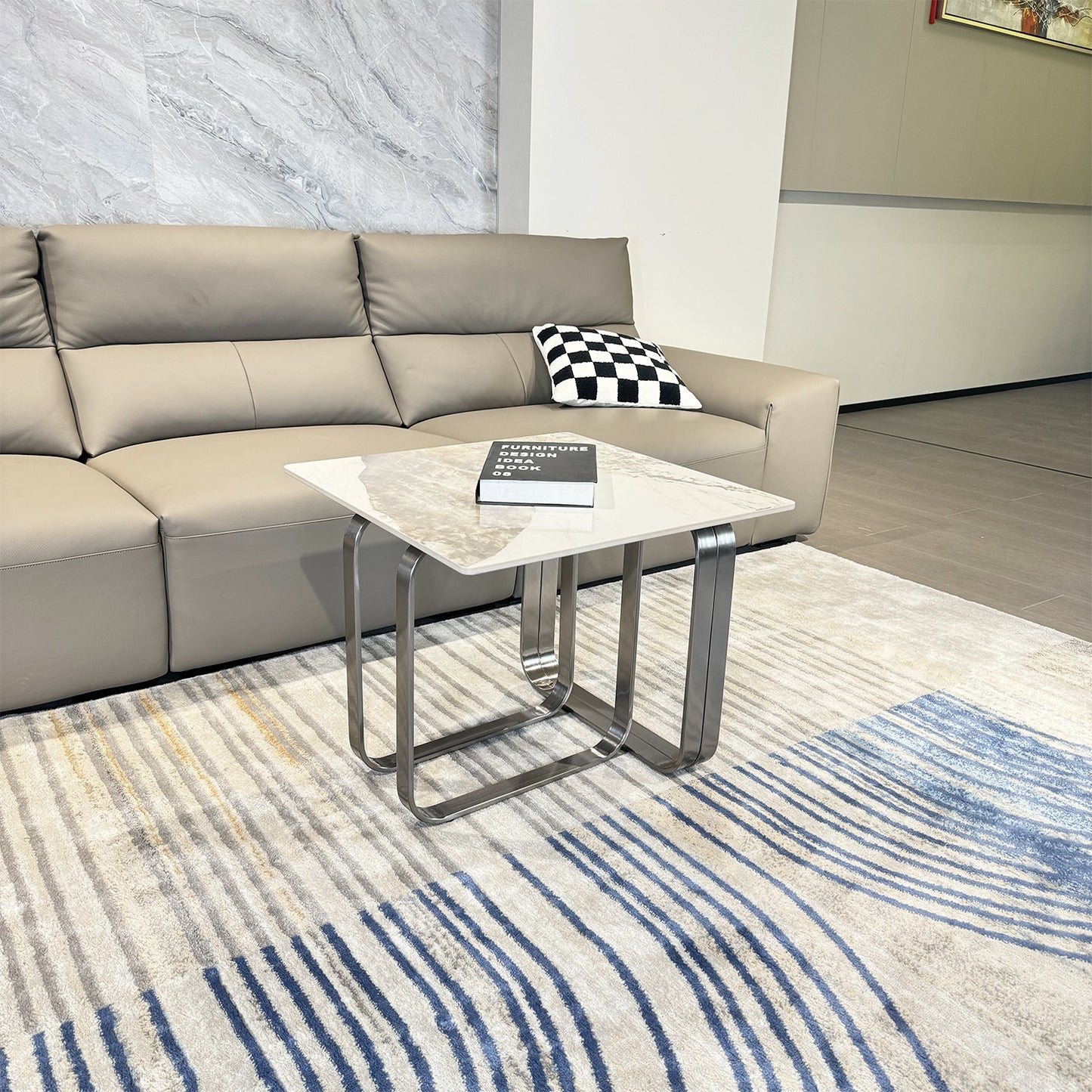Contemporary grey leather sectional sofa with a marbletop coffee table on an abstract striped rug