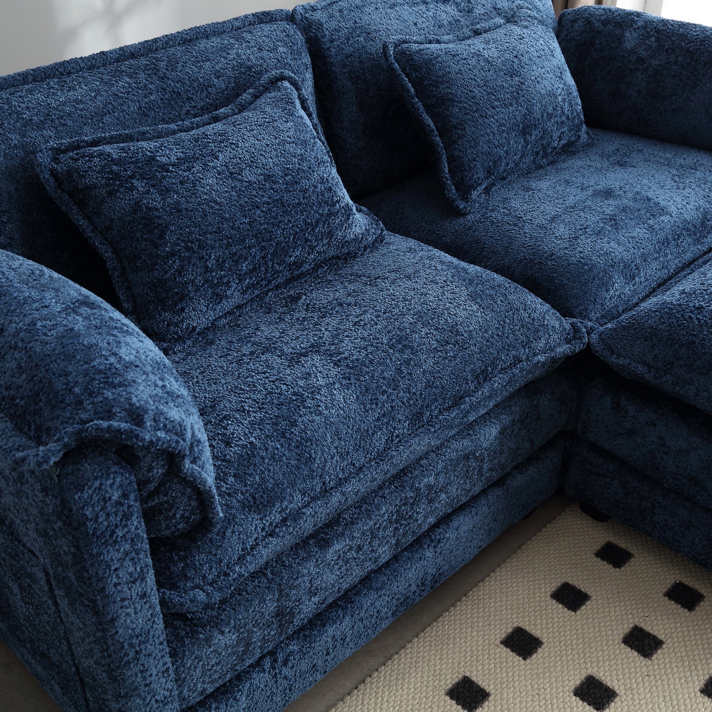 Plush navy blue sectional sofa with textured fabric and matching throw pillows