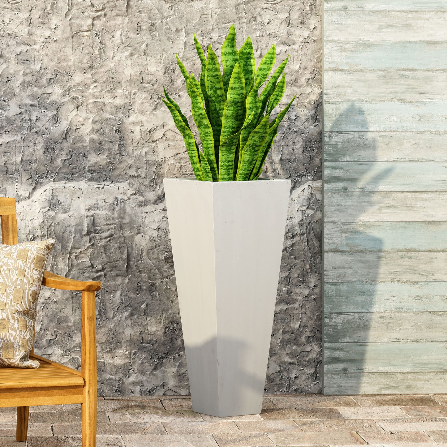 Tall offwhite concrete planter with a snake plant complementing outdoor patio decor