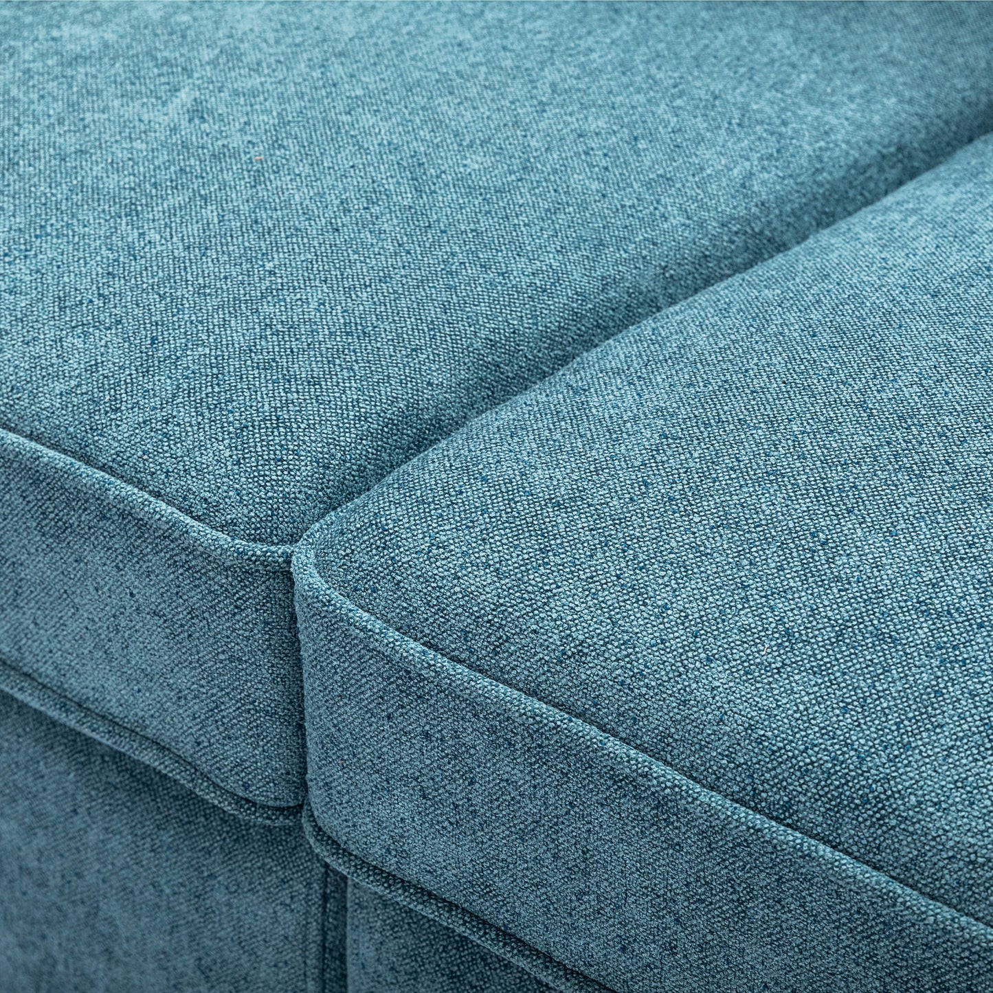 Closeup of a textured teal fabric sofa cushion with visible weave for comfort