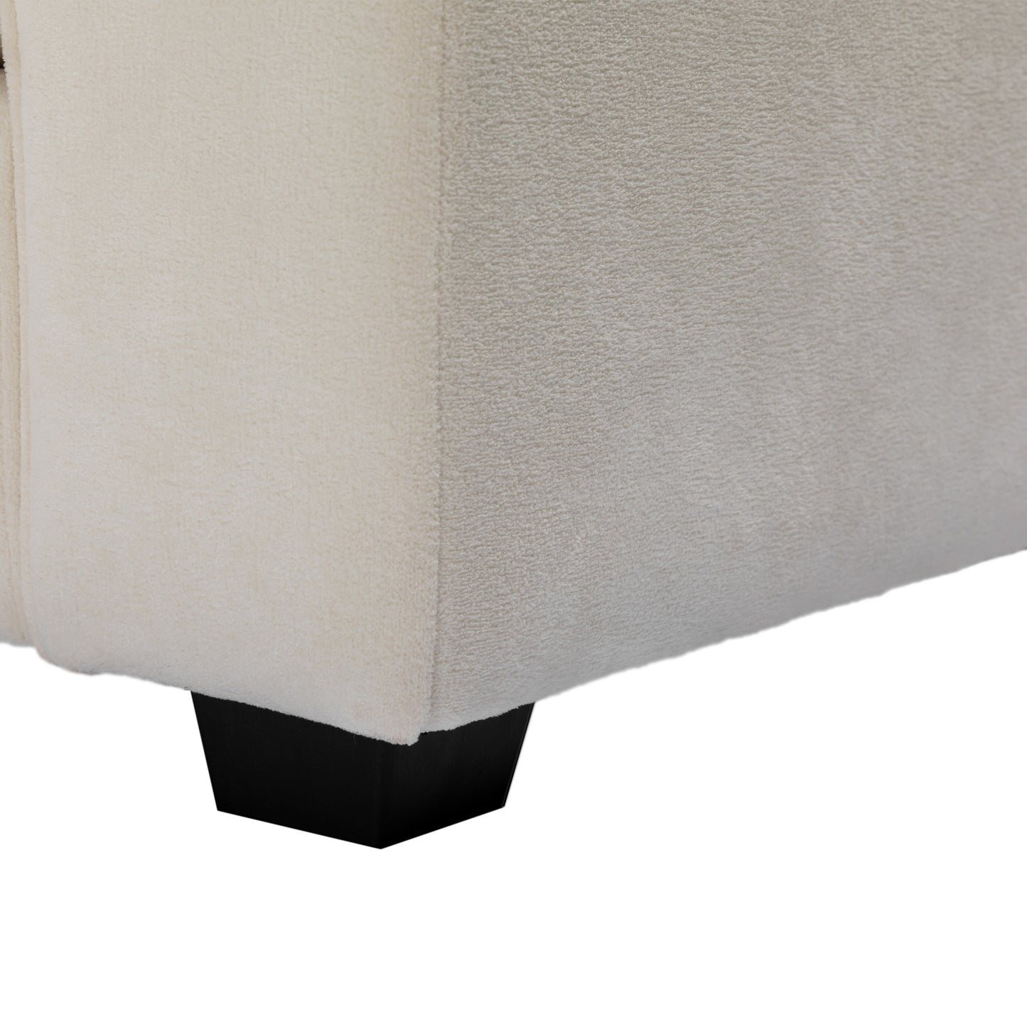 Cream boucle fabric sofa corner detail with black wooden leg