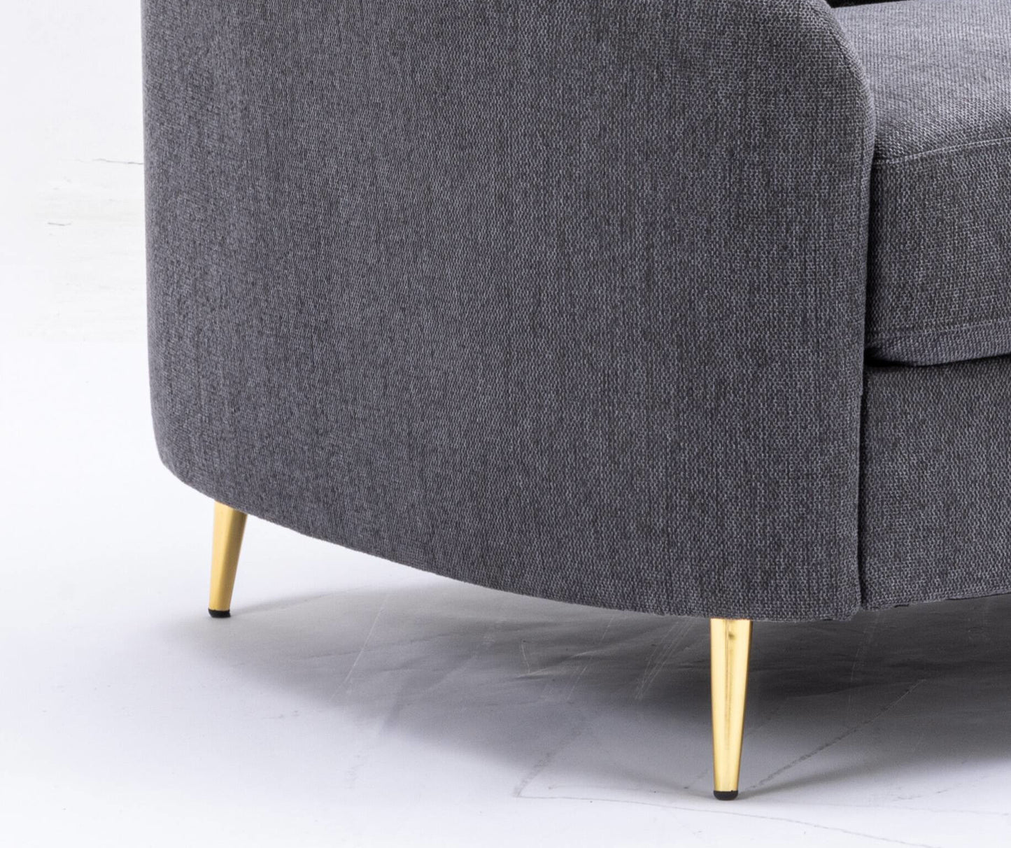 Closeup of textured dark gray fabric sofa with tapered gold legs modern living room furniture