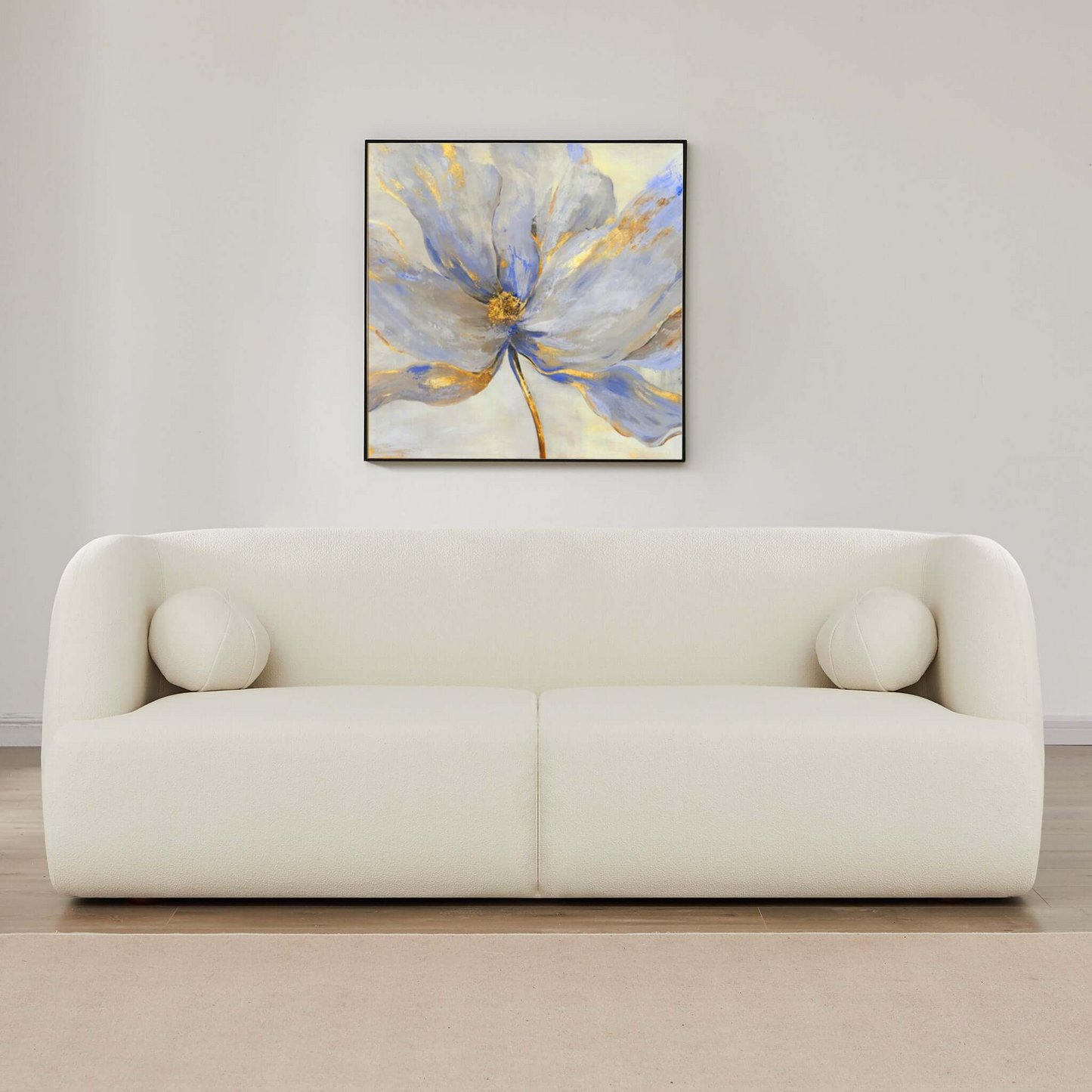 Cream boucle sofa with rounded arms and two circular accent pillows modern design