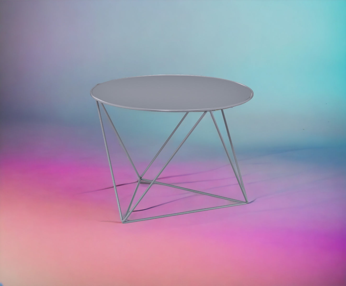 Grey round metal side table with abstract geometric legs perfect for modern living rooms