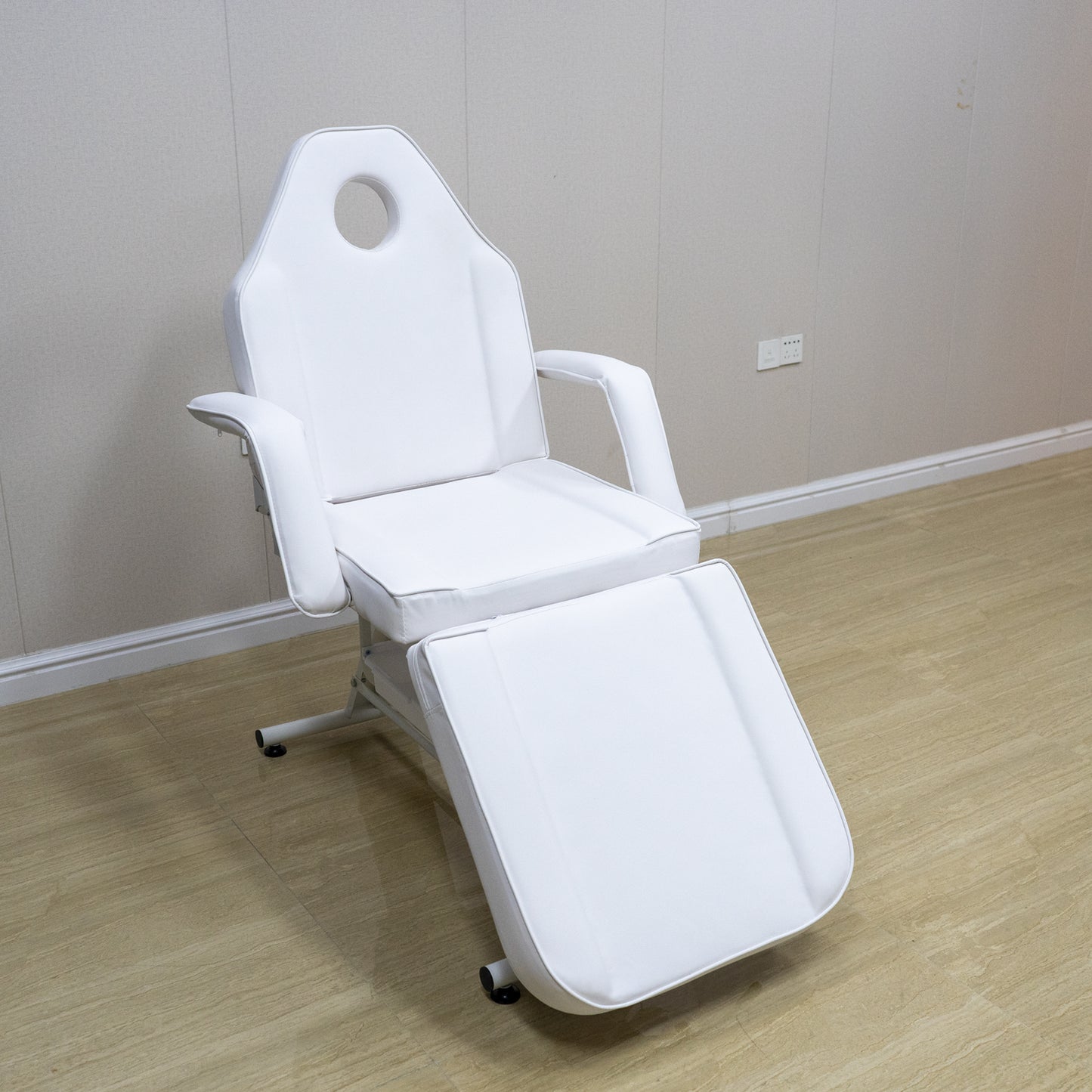 White reclining spa bed with adjustable footrest and headrest hole for facials