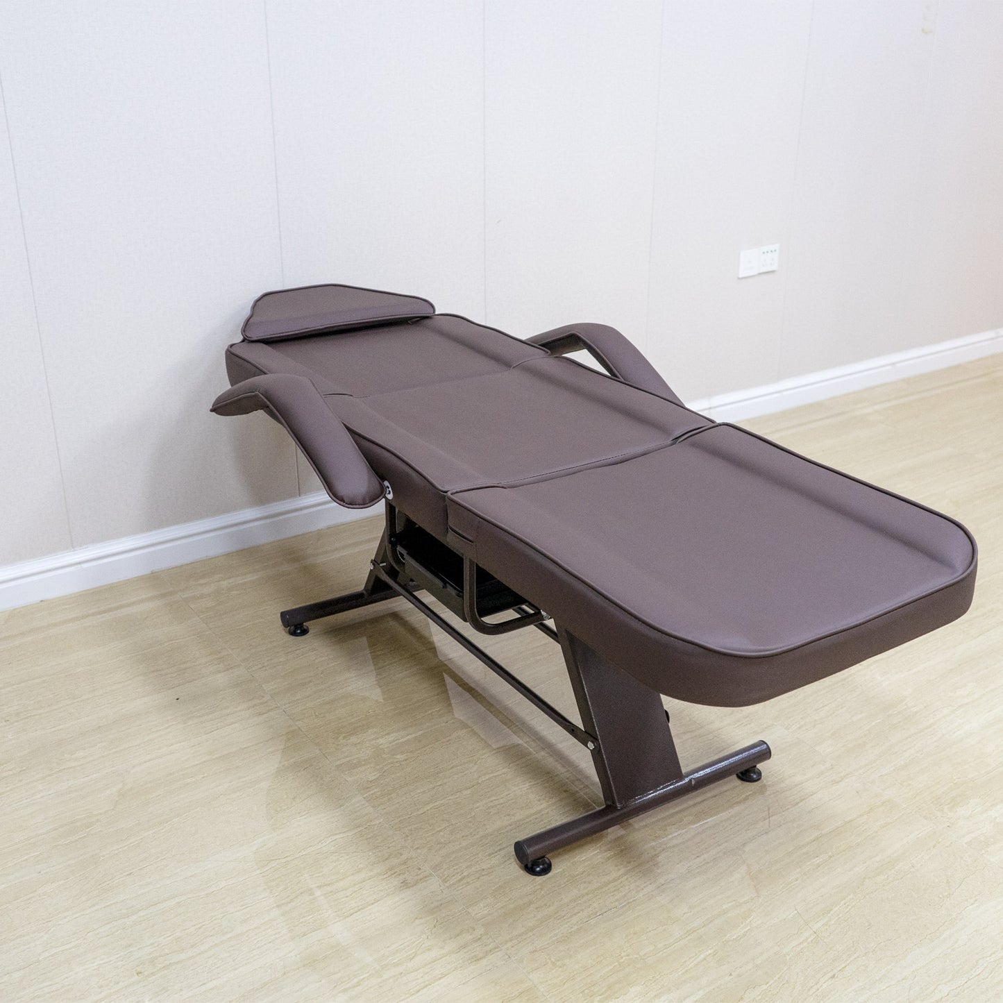 Brown adjustable massage table with padded headrest and armrests ideal for spa treatments