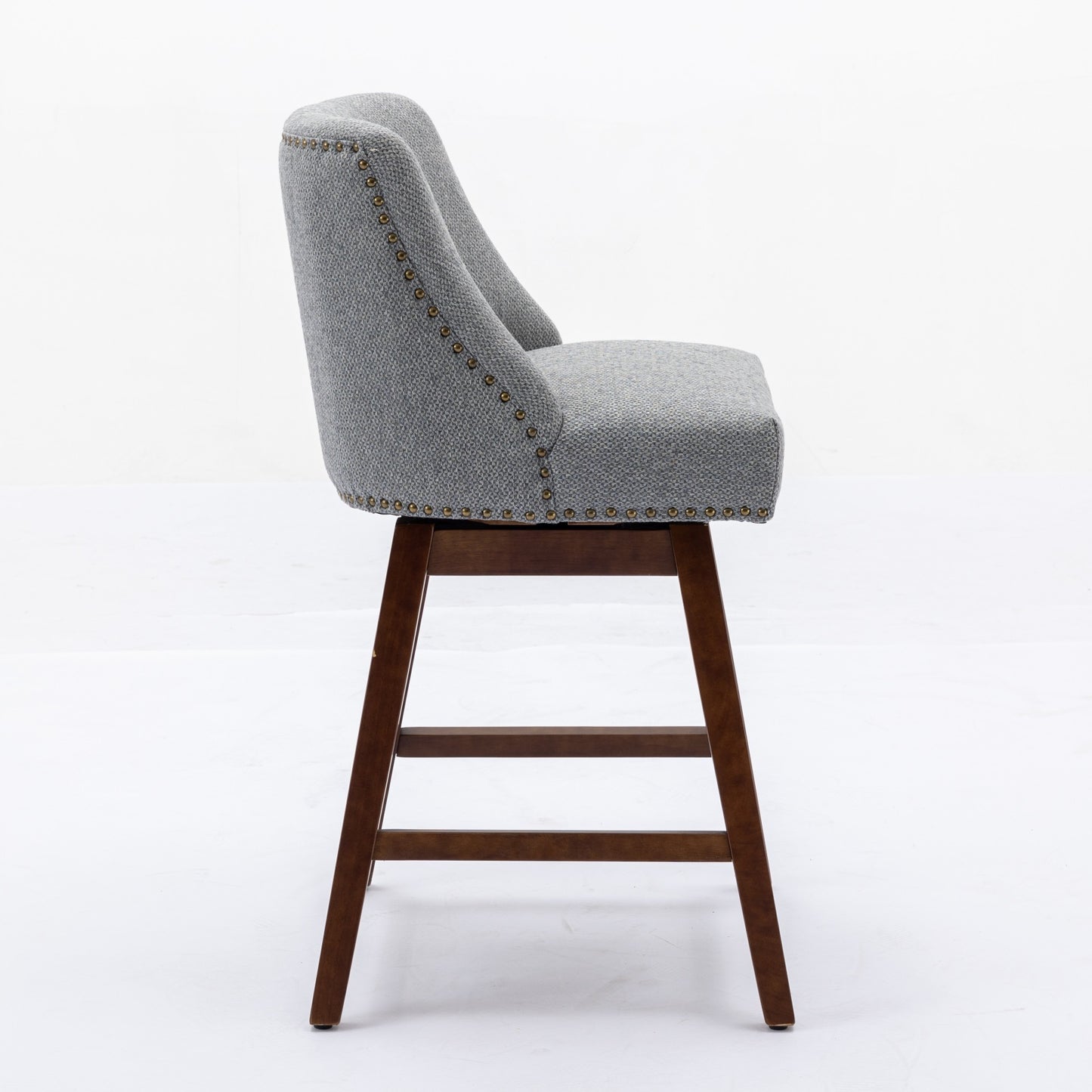 Gray upholstered swivel bar stool with bronze nailhead trim and wooden legs