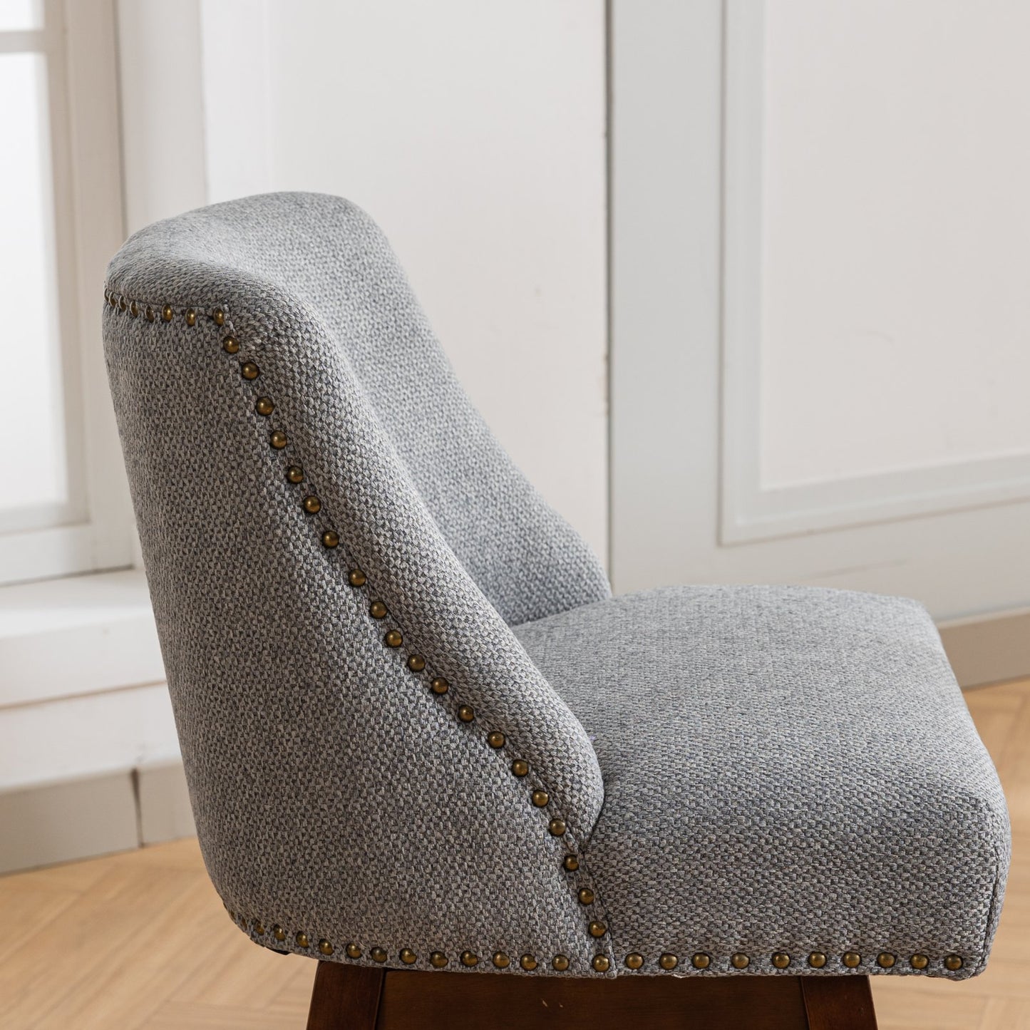 Gray fabric armchair with antique brass nailhead trim perfect for any living room