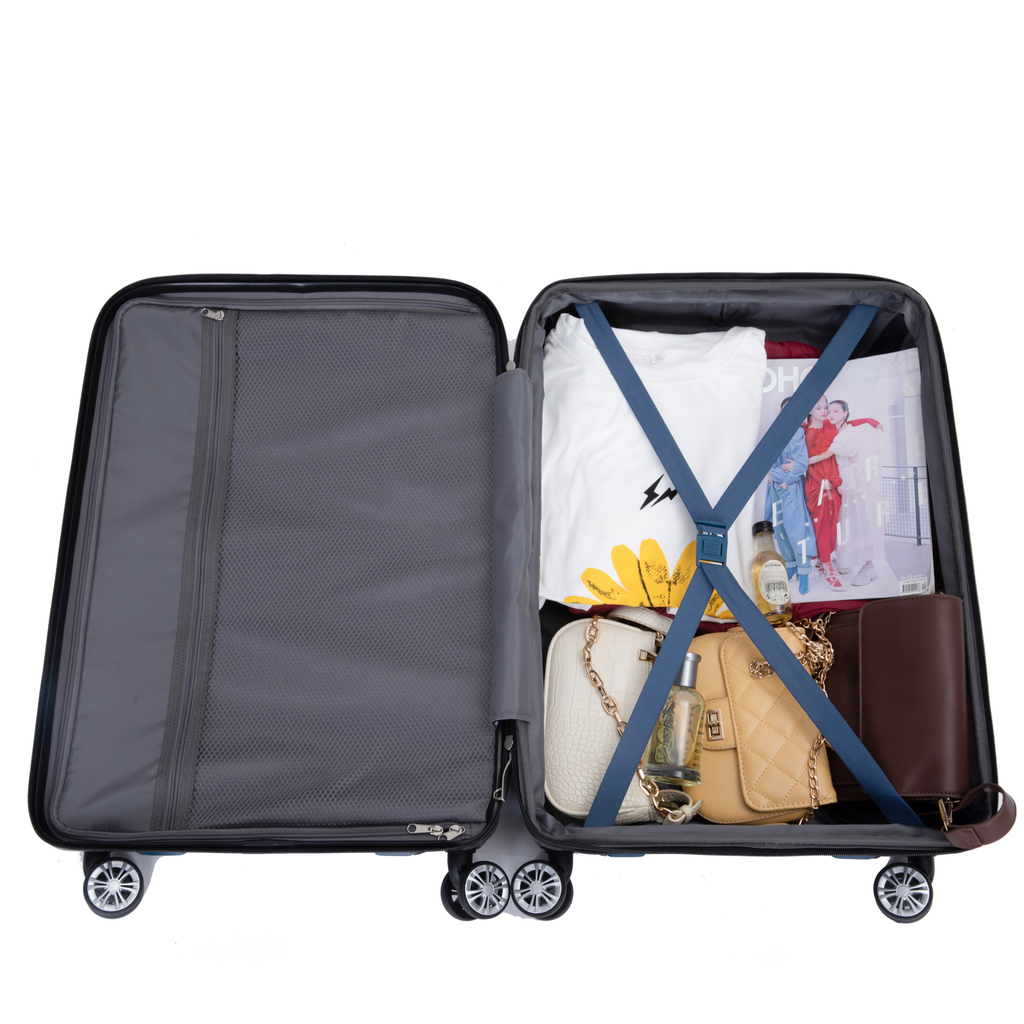 Open suitcase packed with travel essentials white graphic tee magazines two designer handbags and toiletries