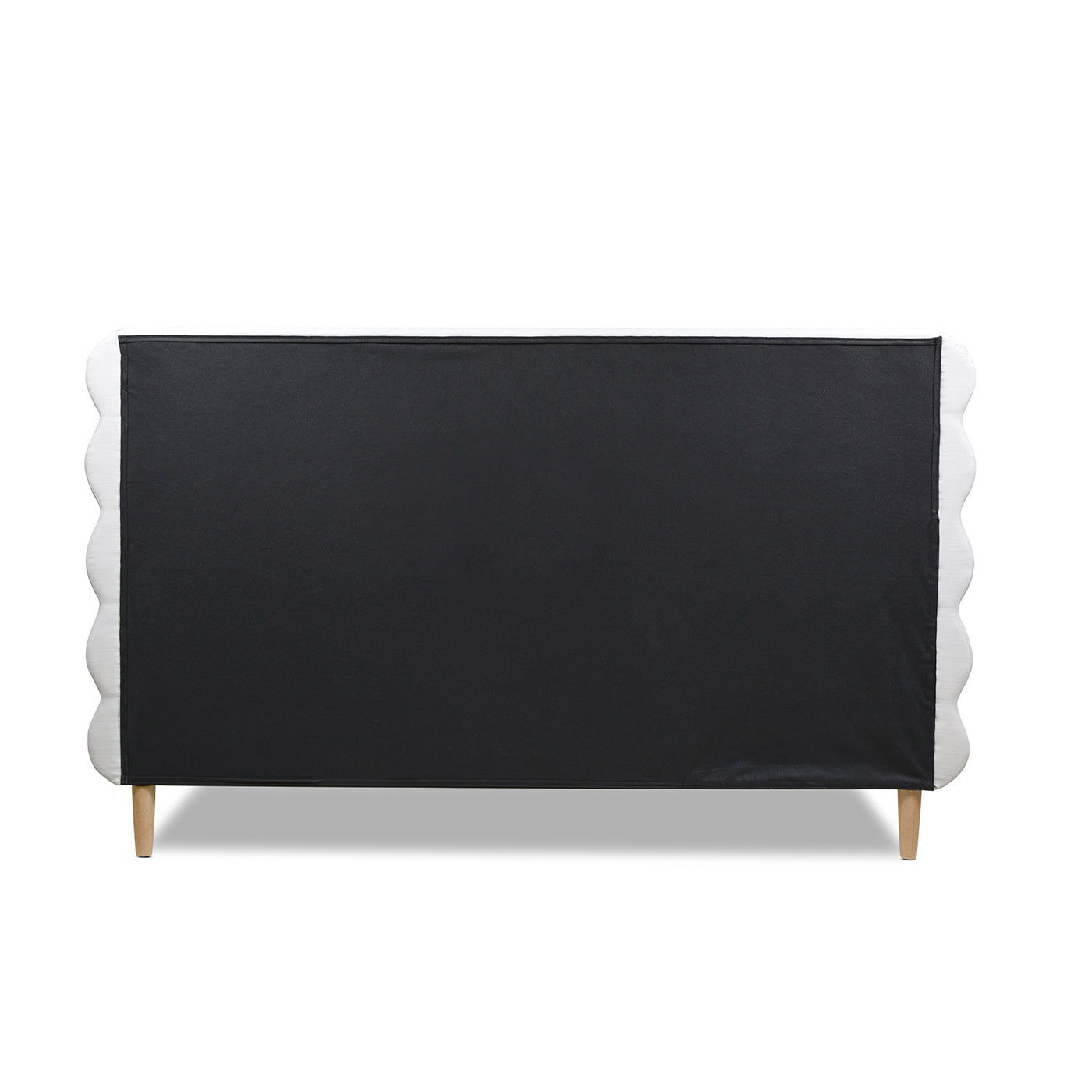 Tufted white scalloped headboard with black fabric backing and wooden legs
