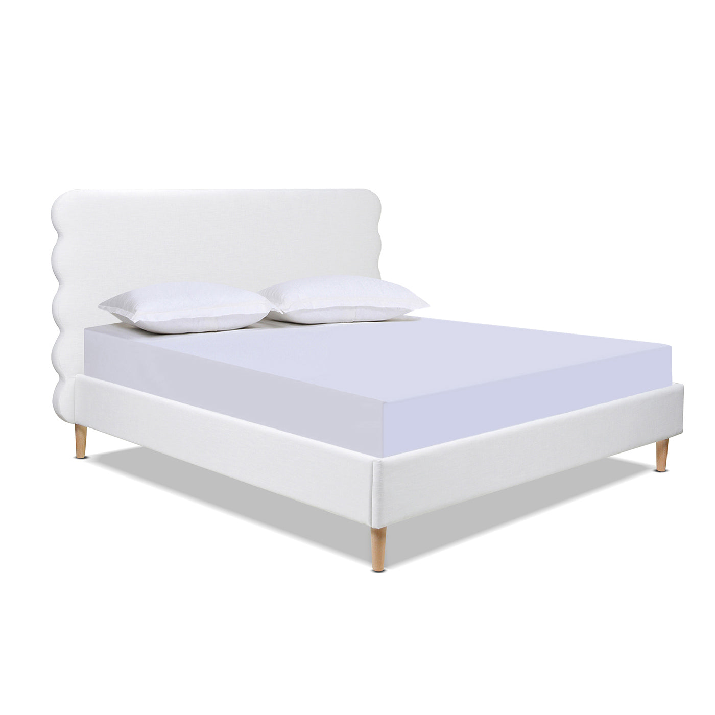 White upholstered platform bed with scalloped headboard and wooden legs