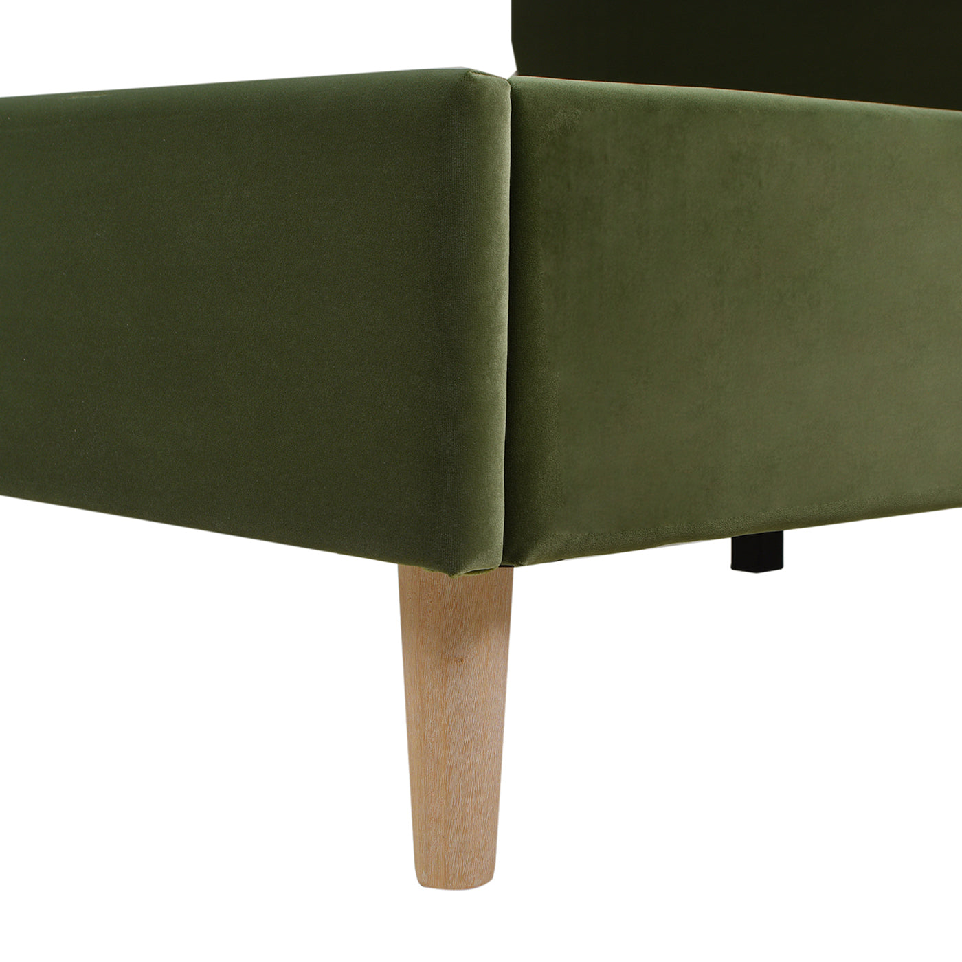 Green velvet sofa corner with tapered wooden legs
