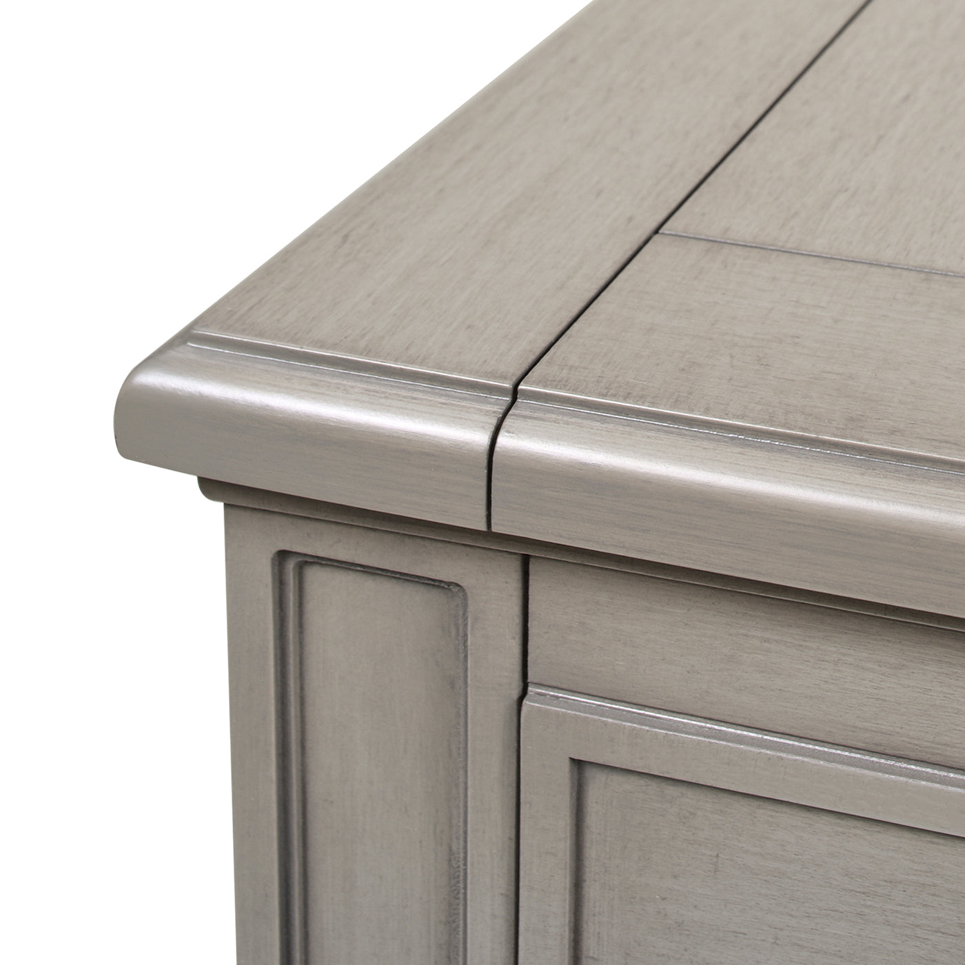 Closeup of a weathered grey wooden cabinet with carved detailing and smooth edges