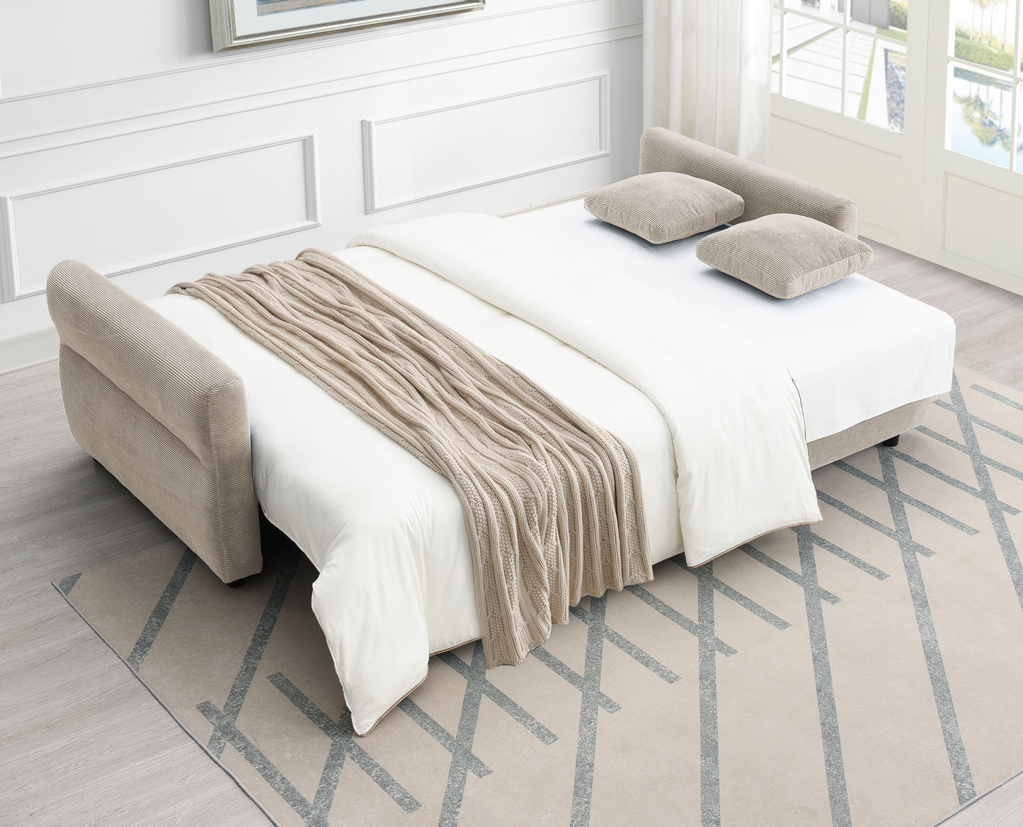 Beige corduroy sofa bed with white bedding and a chunky knit throw