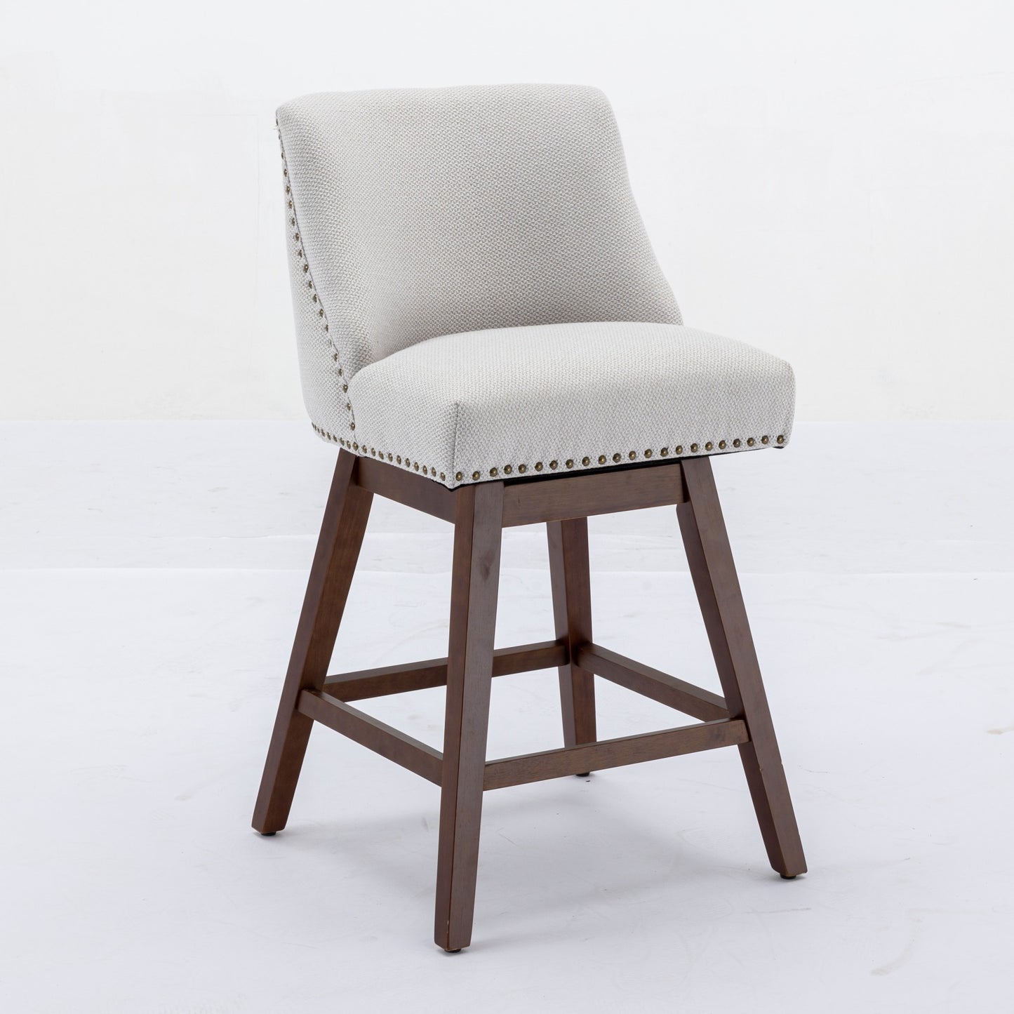 Swivel bar stool with light grey textured fabric nailhead trim and dark wood legs